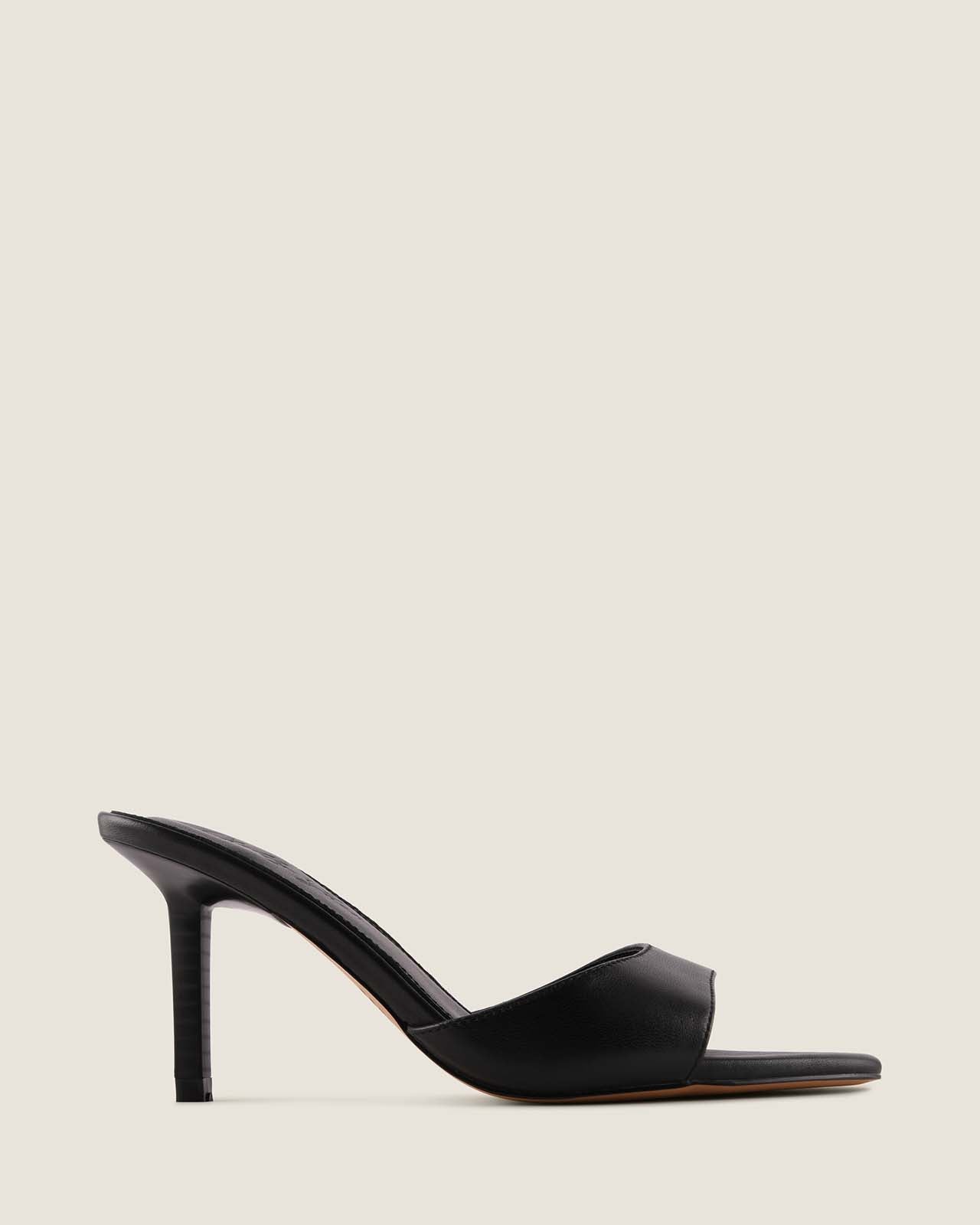Black high-heeled sandal on a light beige background