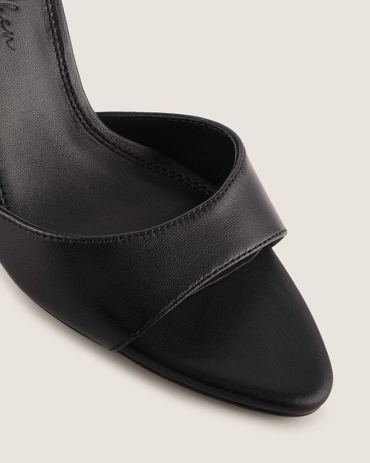Black high-heeled shoe on a light gray background