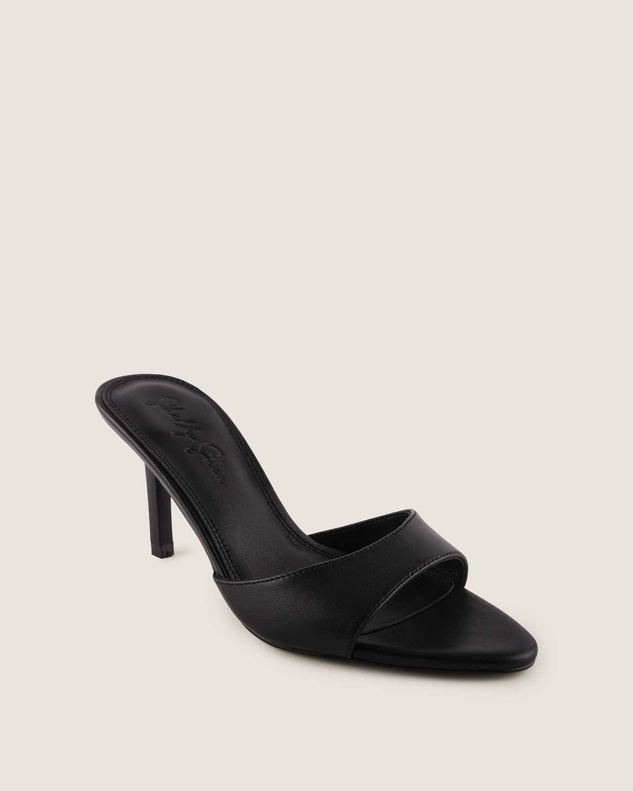 Black high-heeled sandal on a light beige background