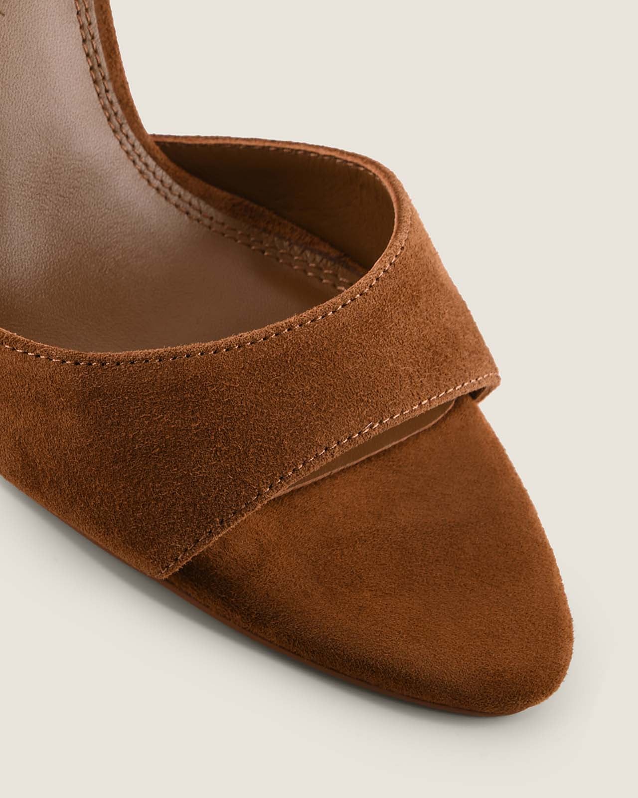 Brown suede shoe on a light beige background