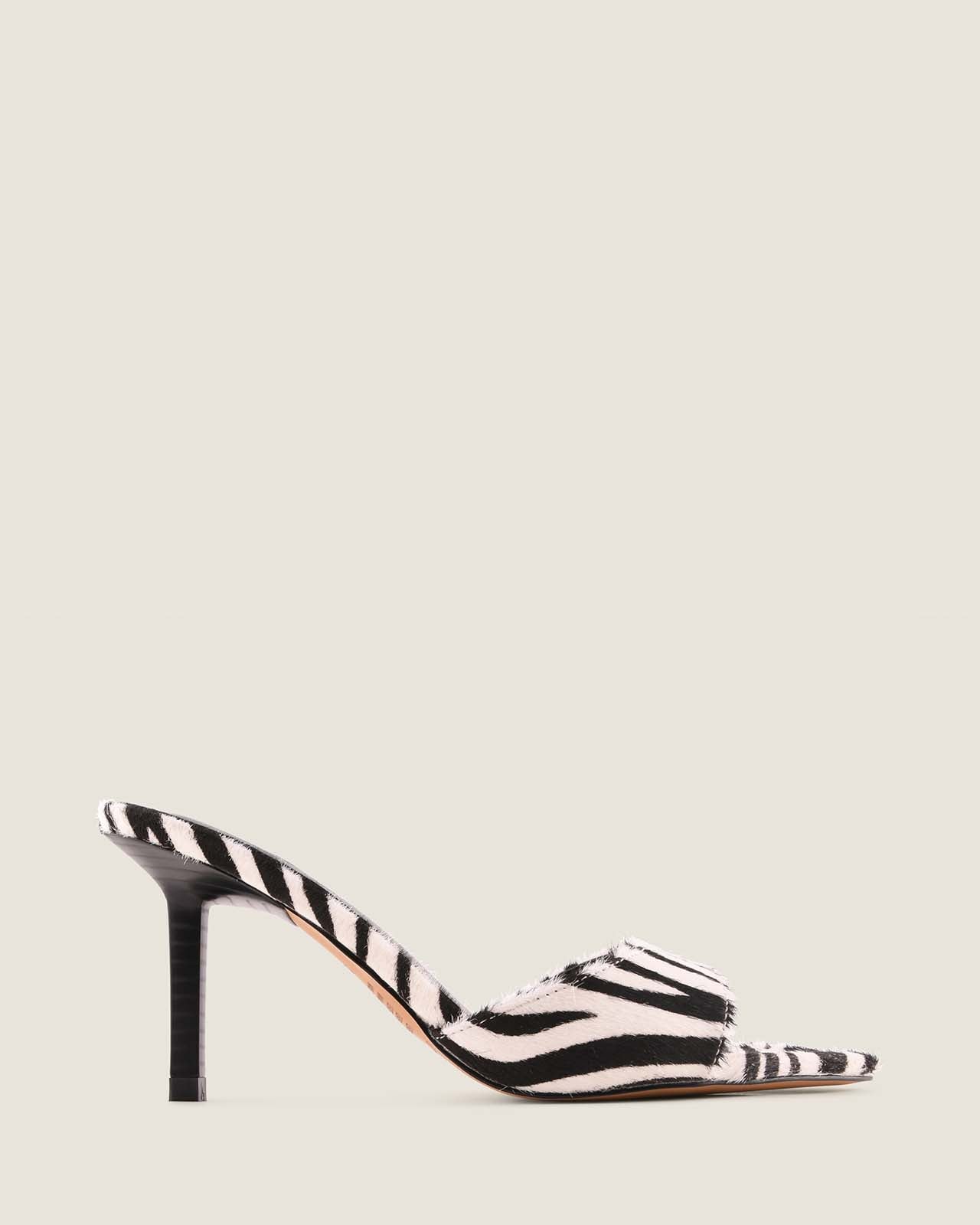 Zebra-striped high-heeled shoe on a light gray background