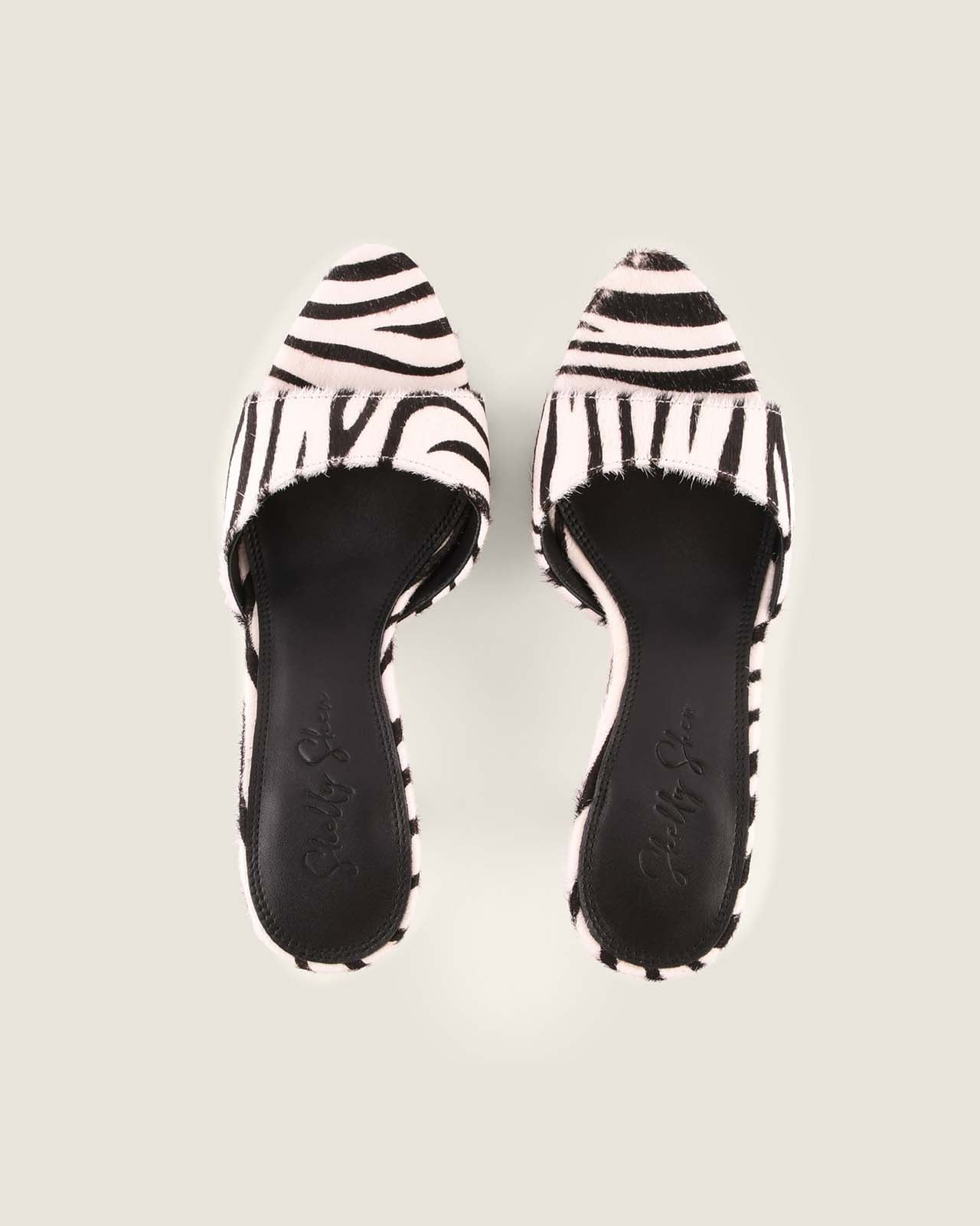 Pair of zebra-striped sandals on a light gray background