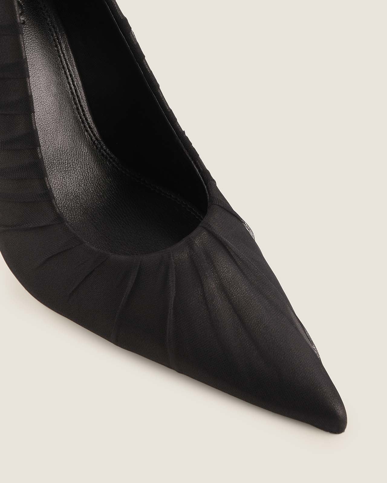 Black pointed-toe shoe on a light gray background