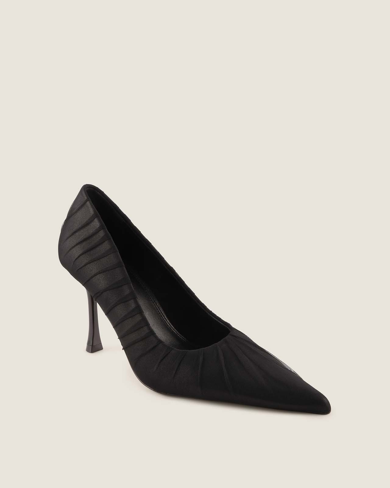 Black high-heeled shoe on a light beige background
