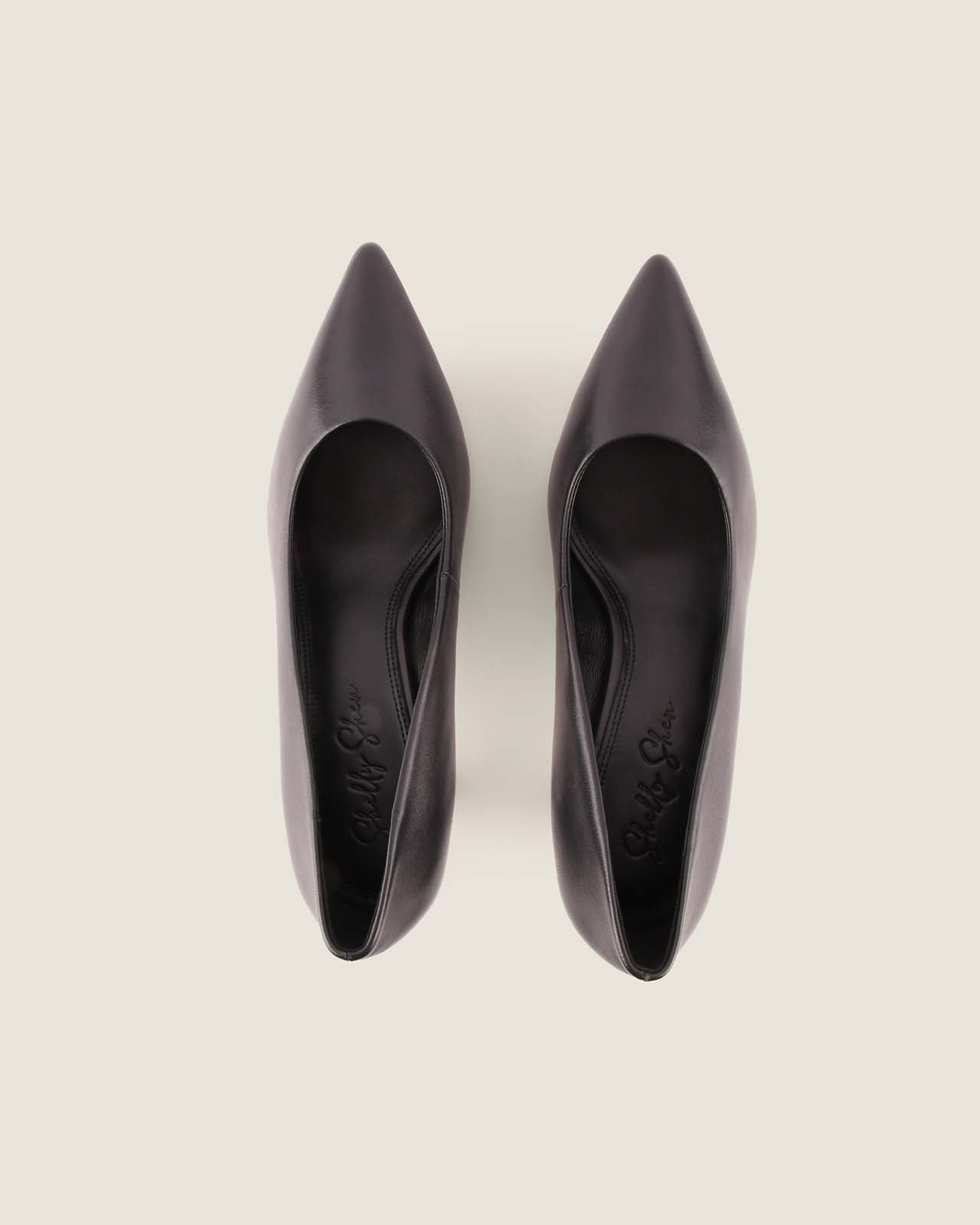 Pair of black pointed-toe shoes on a light gray background
