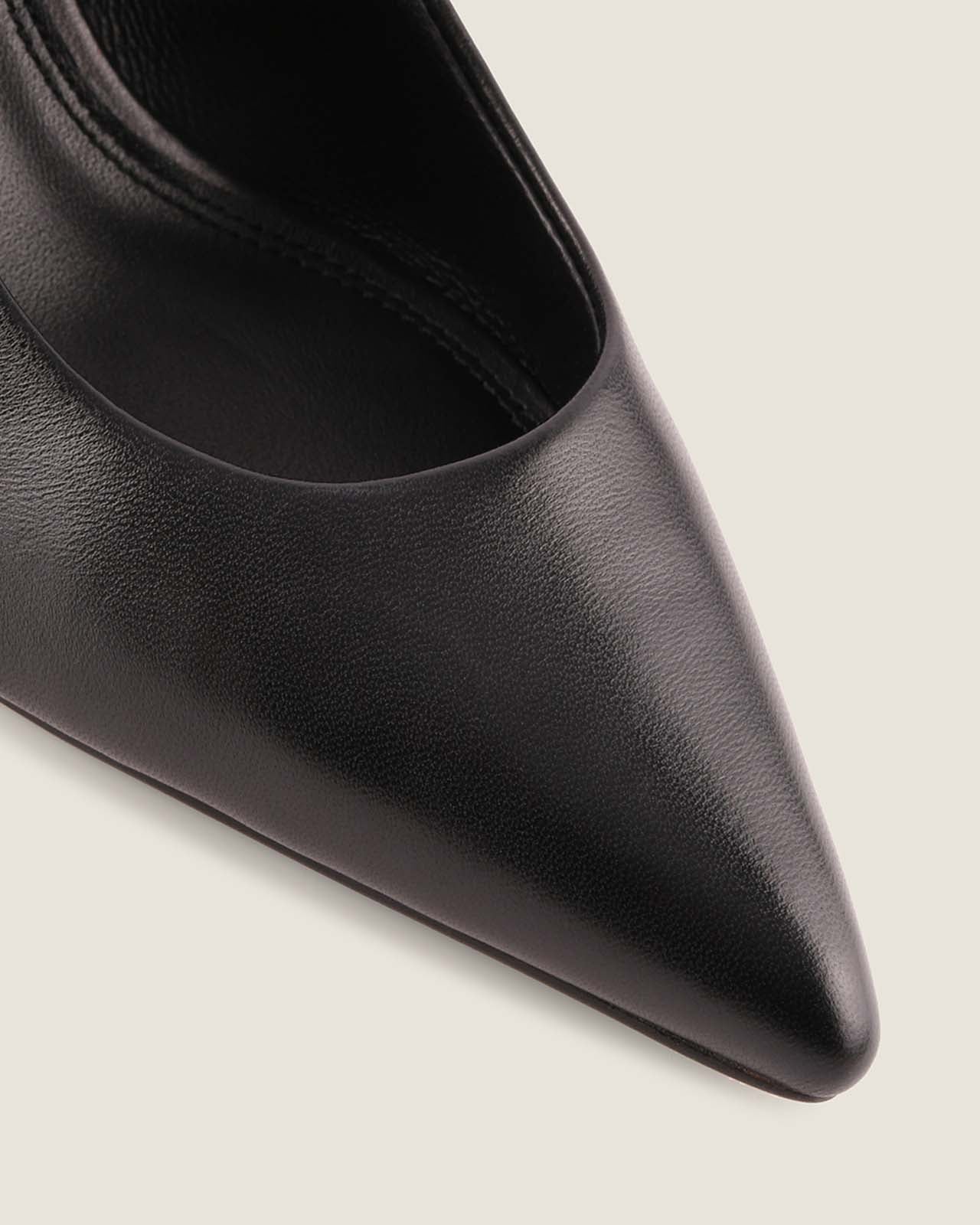 Black pointed-toe shoe on a light gray background