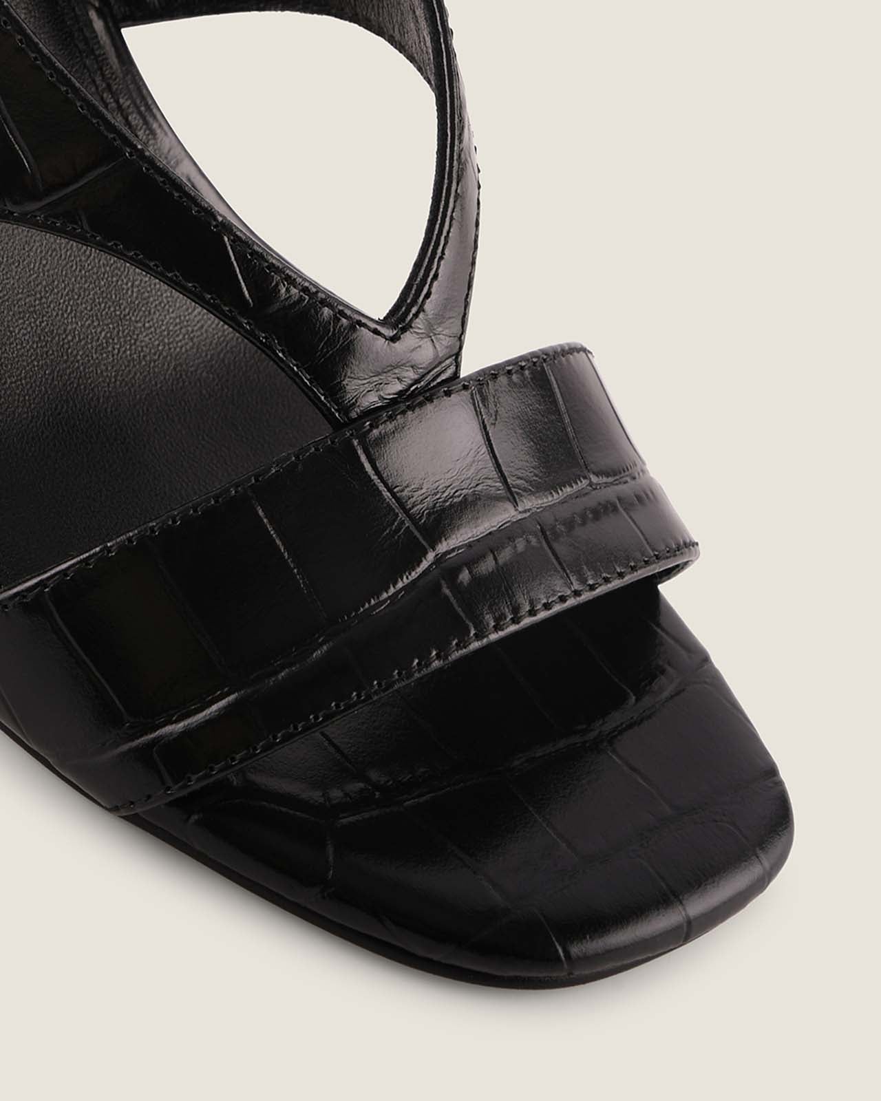 Black sandal with a strap on a light gray background