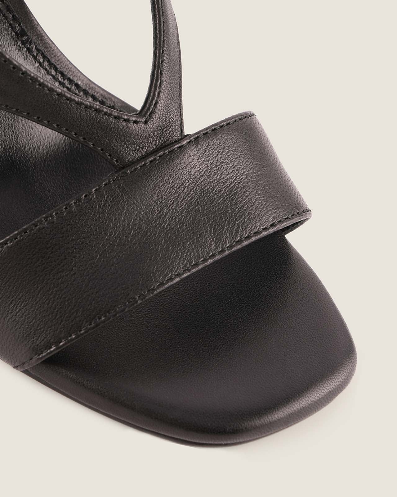 Black sandal with a strap on a light gray background