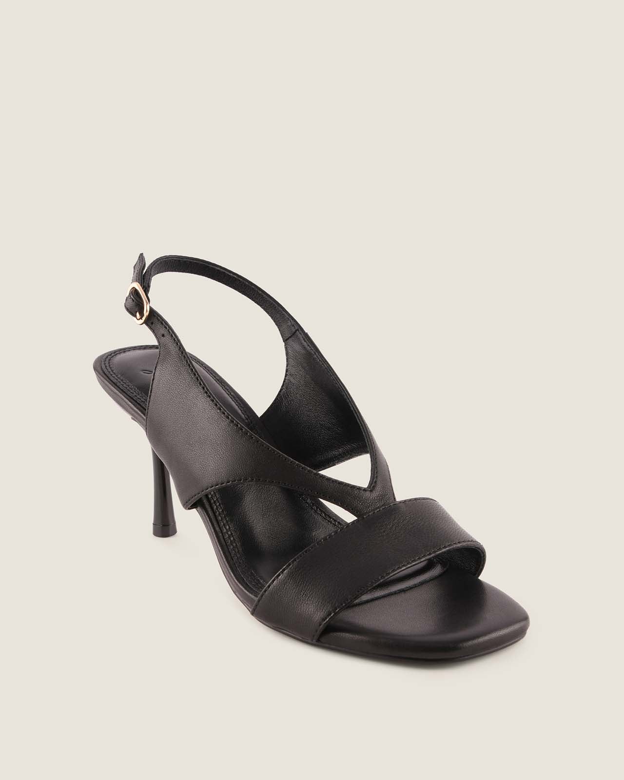 Black sandal with a high heel on a light gray background