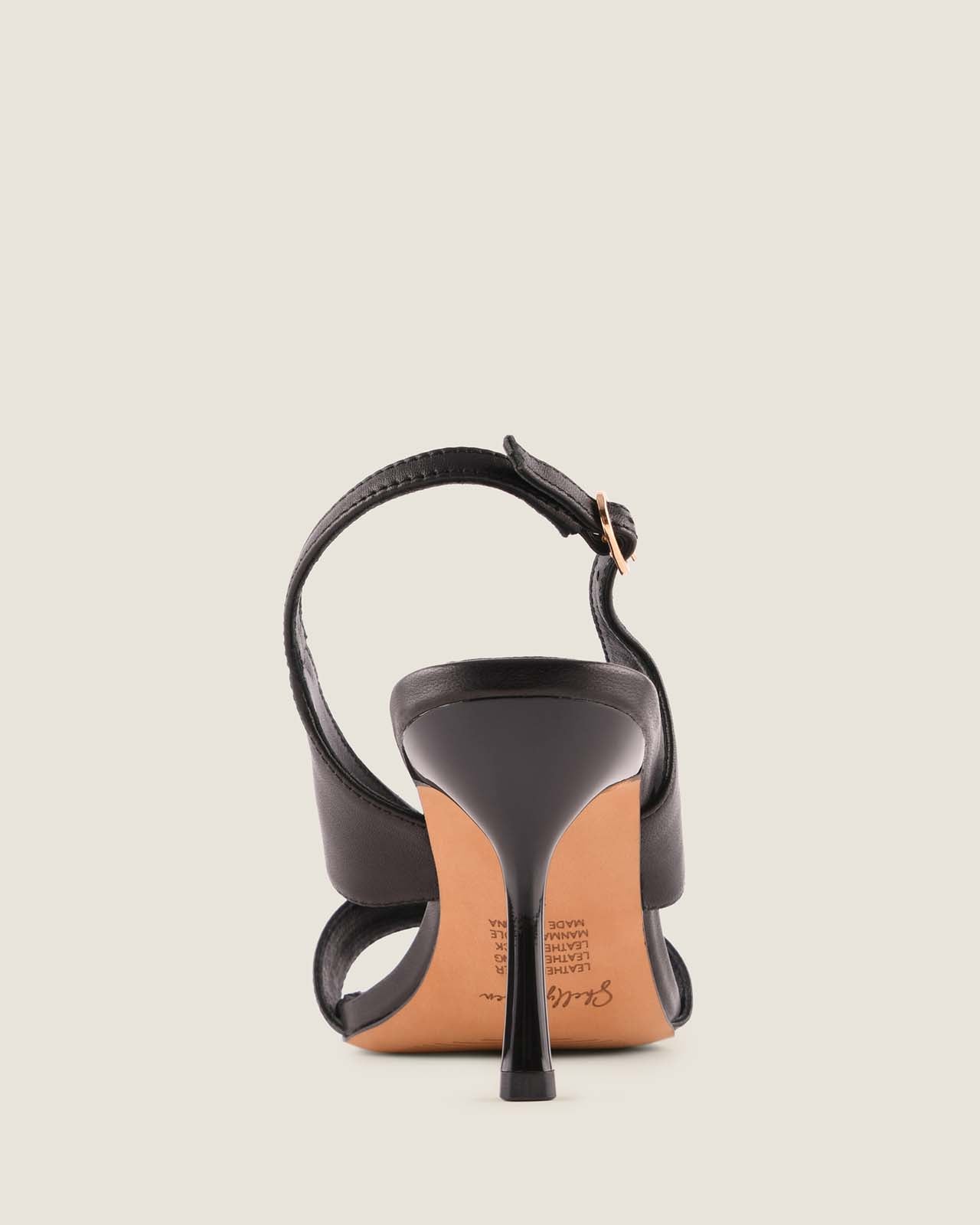 Black high-heeled sandal on a light beige background
