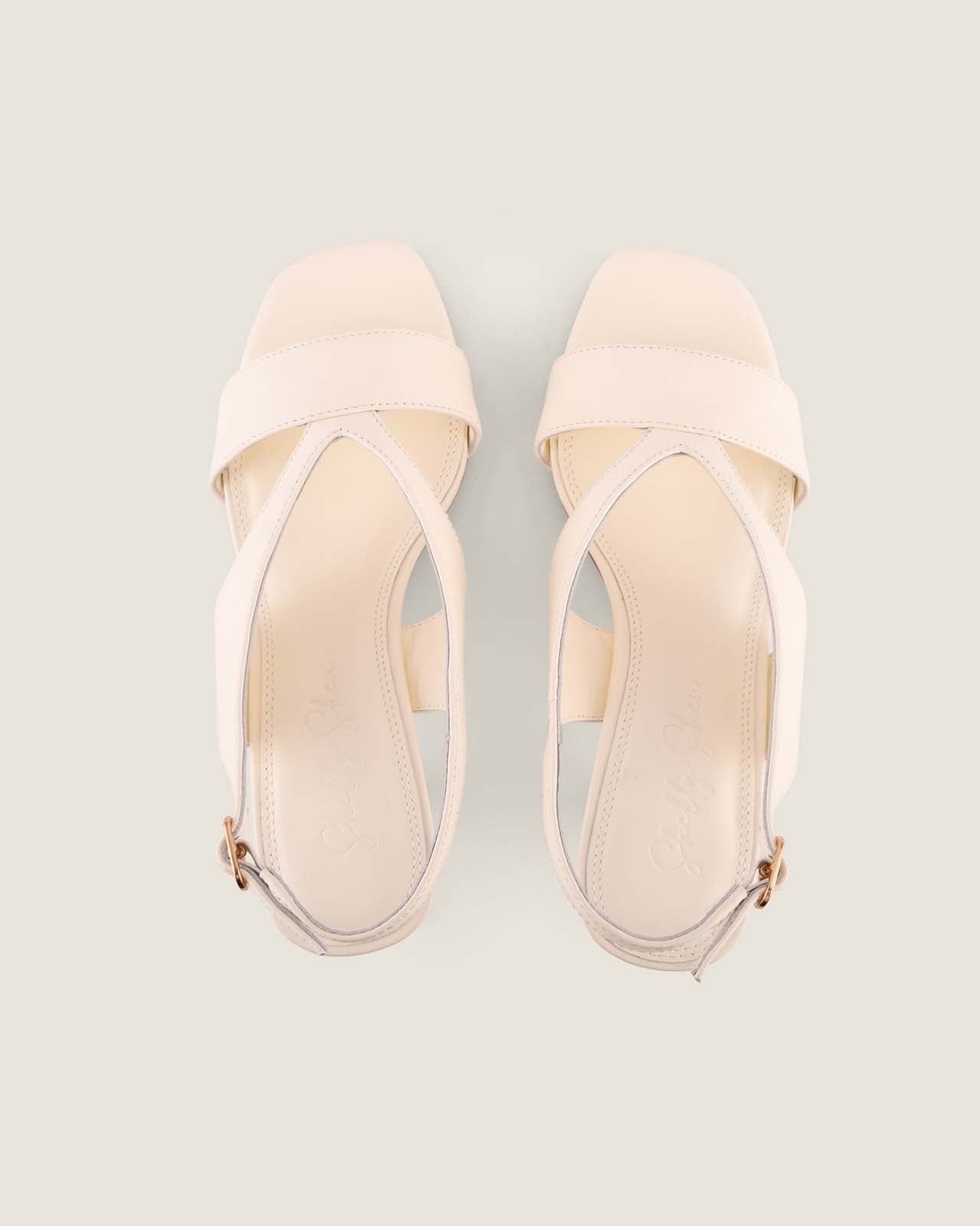 Pair of white high-heeled sandals on a light grey background
