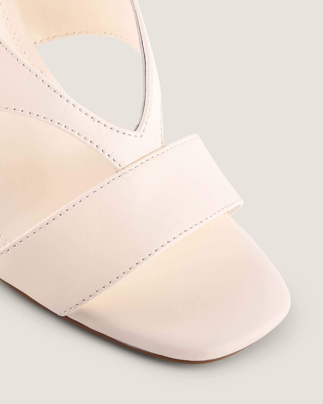 Close-up of a white sandal with a strap on a light grey background