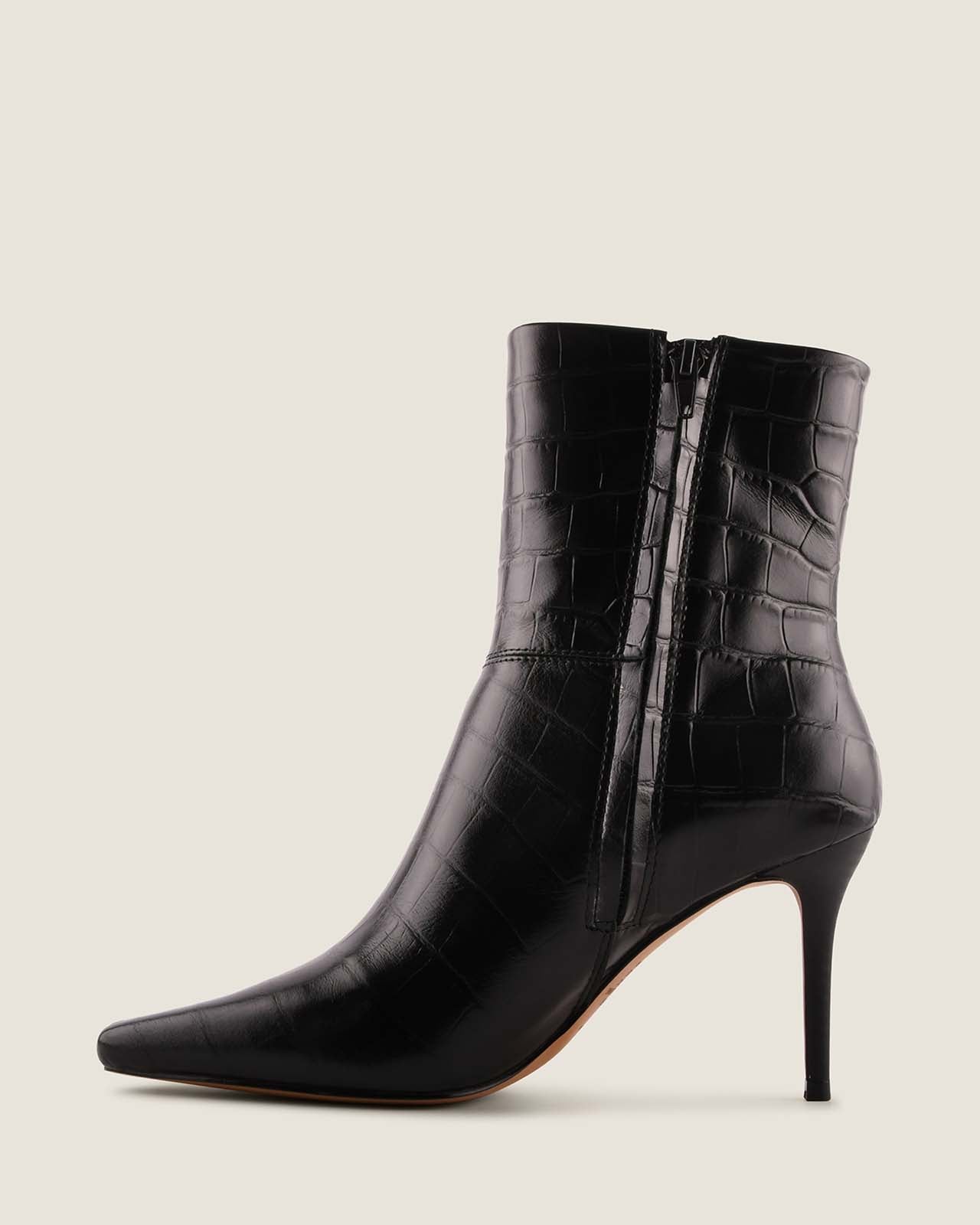 Black crocodile-patterned high-heeled ankle boots on a light grey background