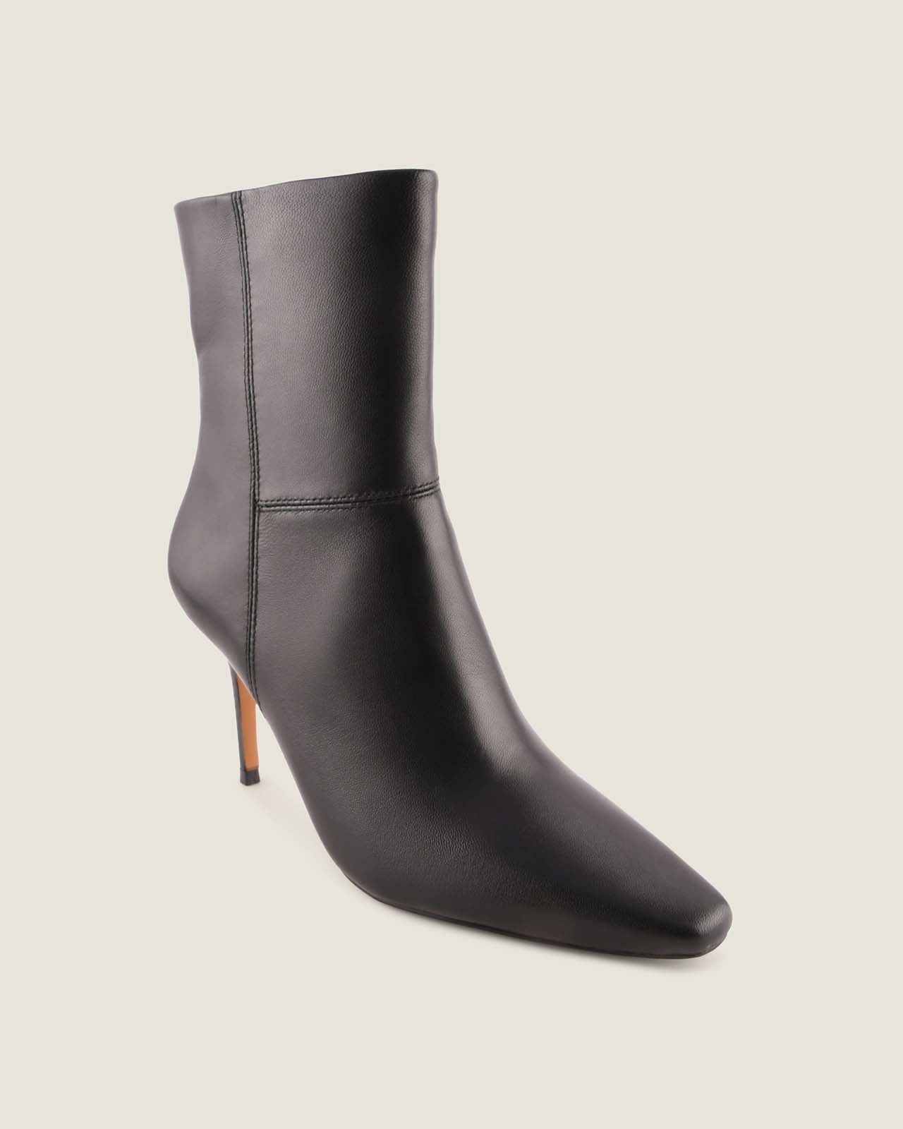 Black ankle boot with a pointed toe on a light grey background