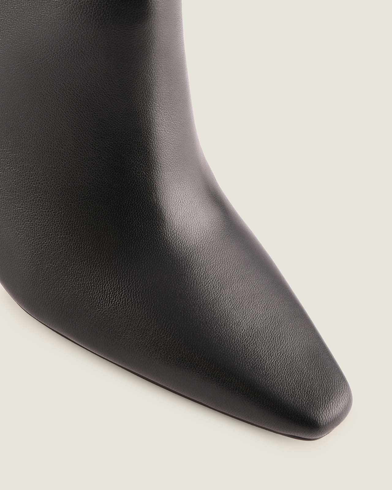 Close-up of a black leather boot on a light background