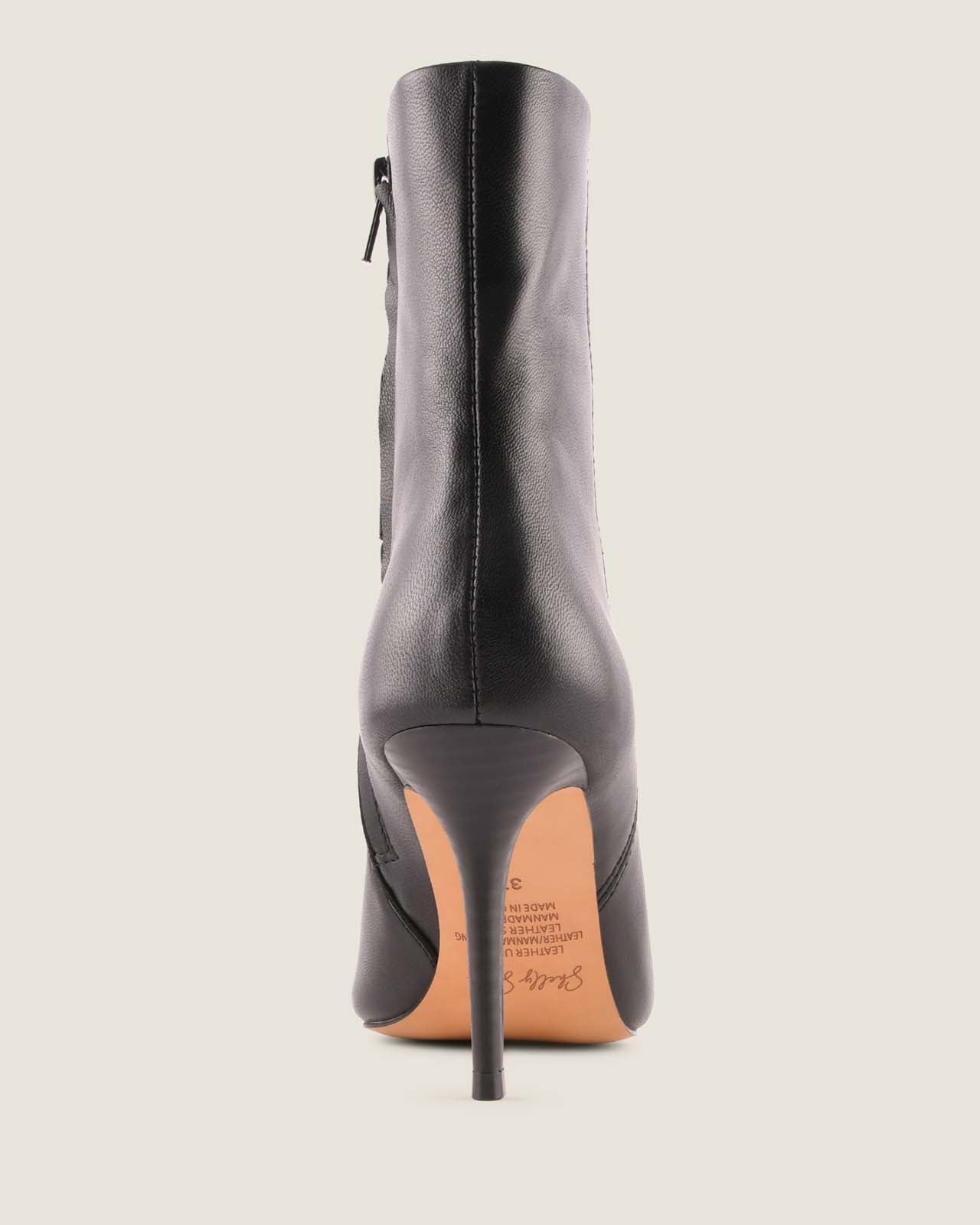 Black high-heeled boot on a light grey background