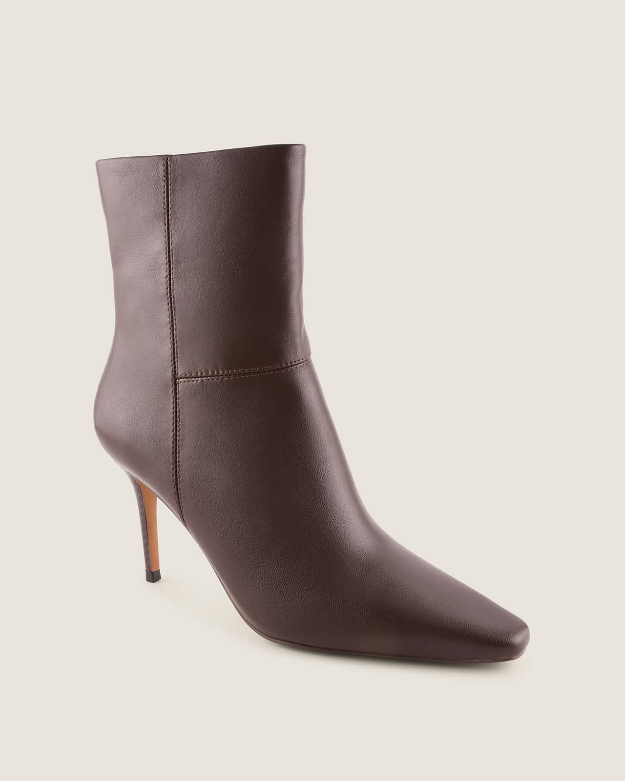 Brown leather ankle boot on a light beige background