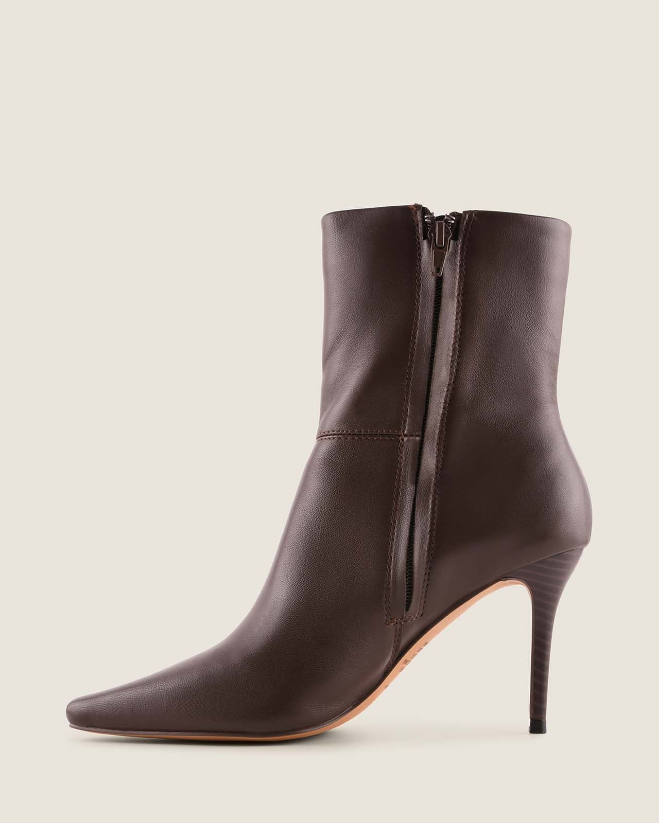 Brown leather ankle boot with a high heel on a beige background