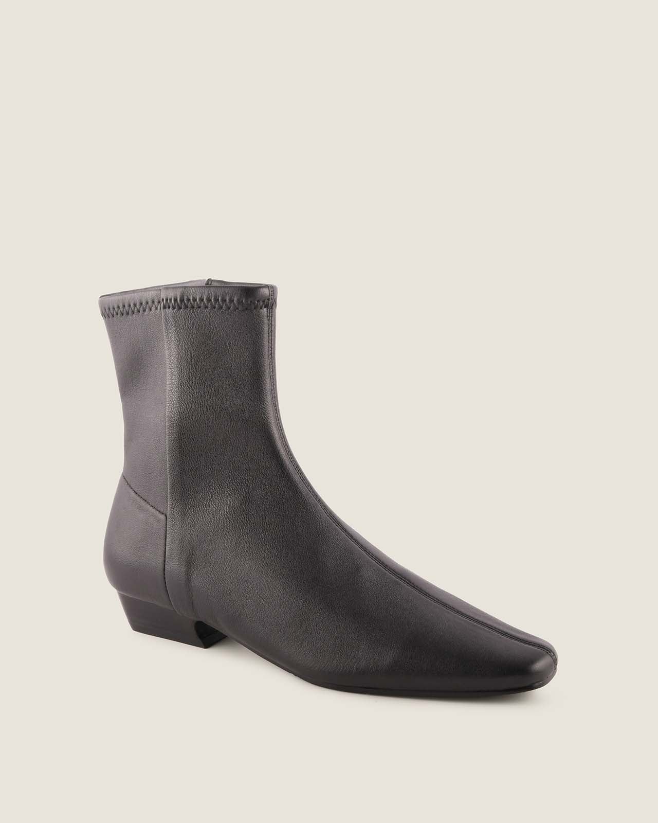 Black ankle boot on a beige background