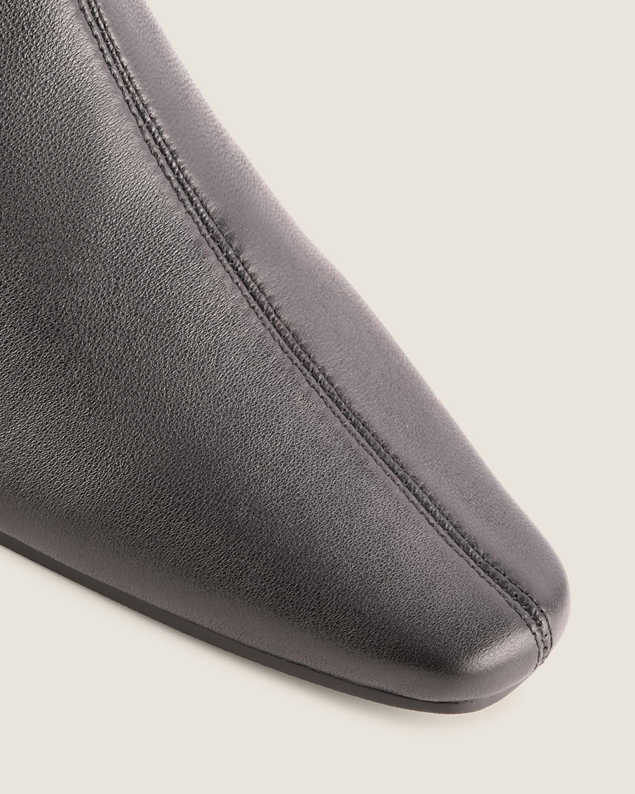 Close-up of a black leather shoe on a light grey background