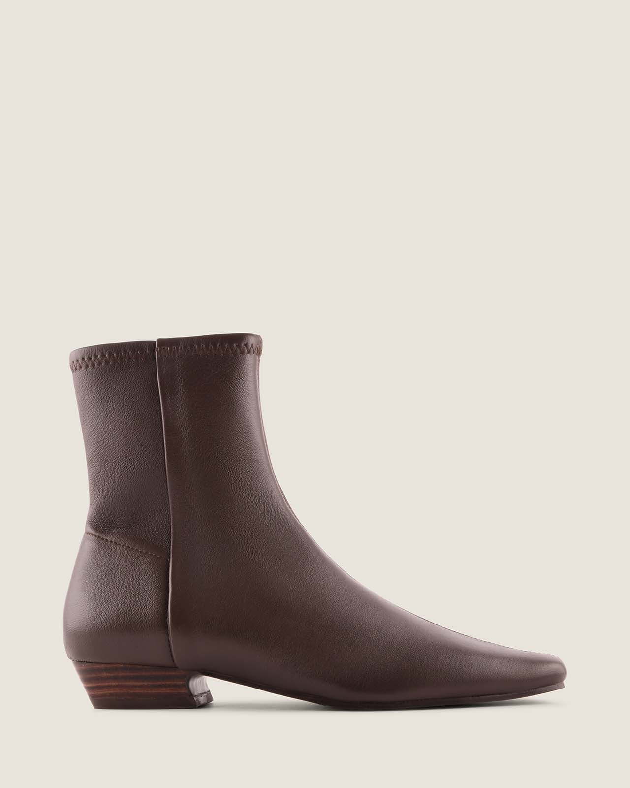 Brown leather ankle boot on a beige background