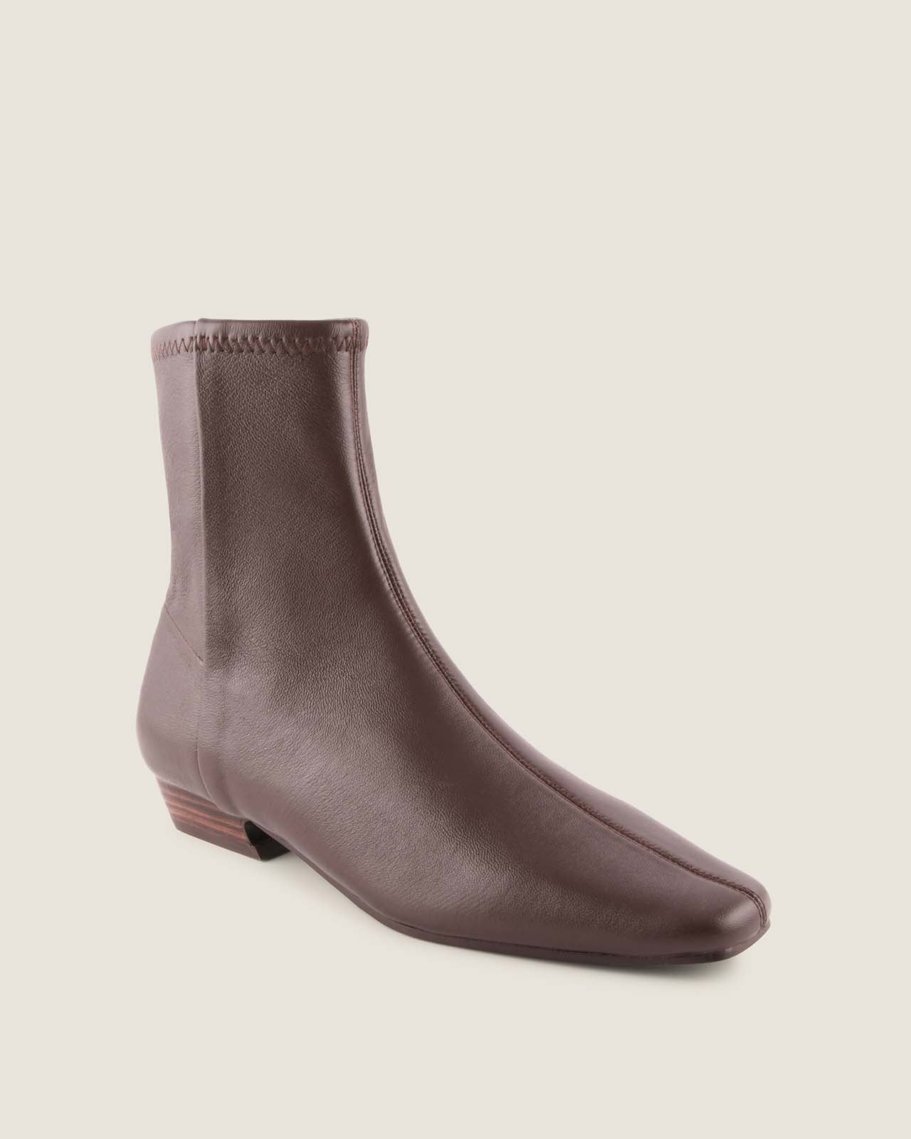 Brown ankle boot on a beige background