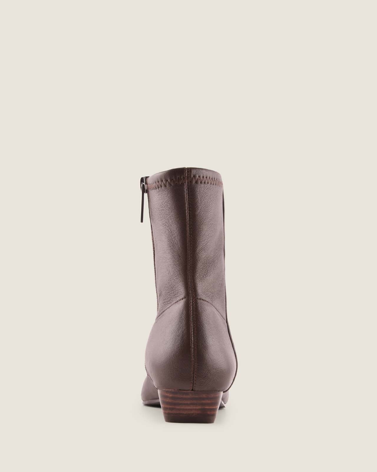 Brown leather ankle boot on a beige background