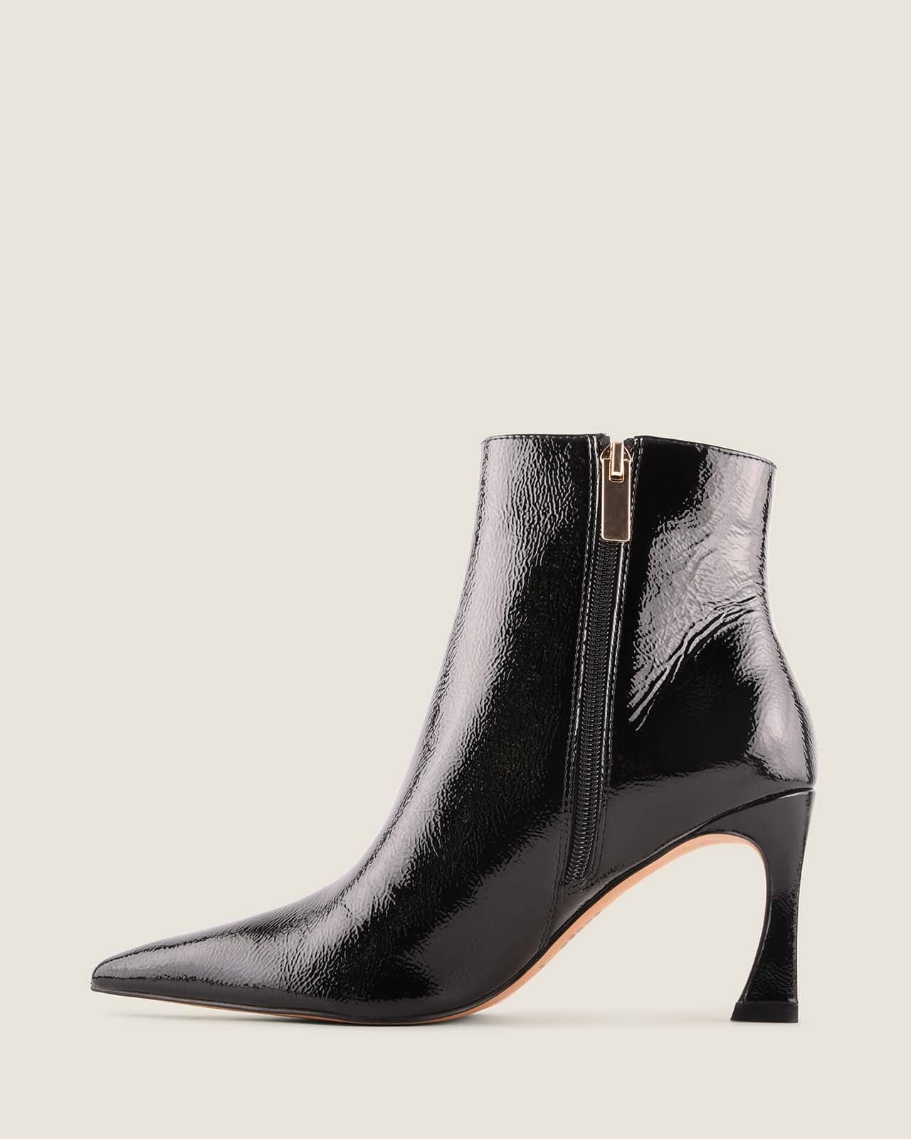 Black patent leather ankle boot with a zipper on a light grey background