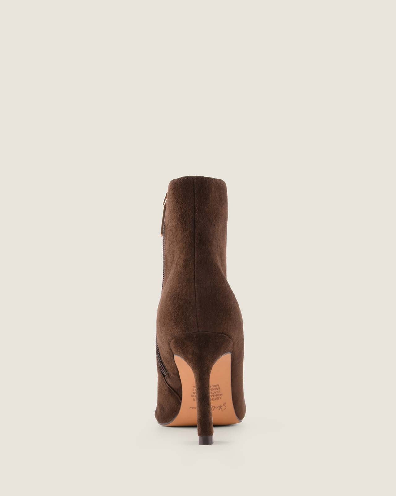 Brown suede ankle boot on a light beige background