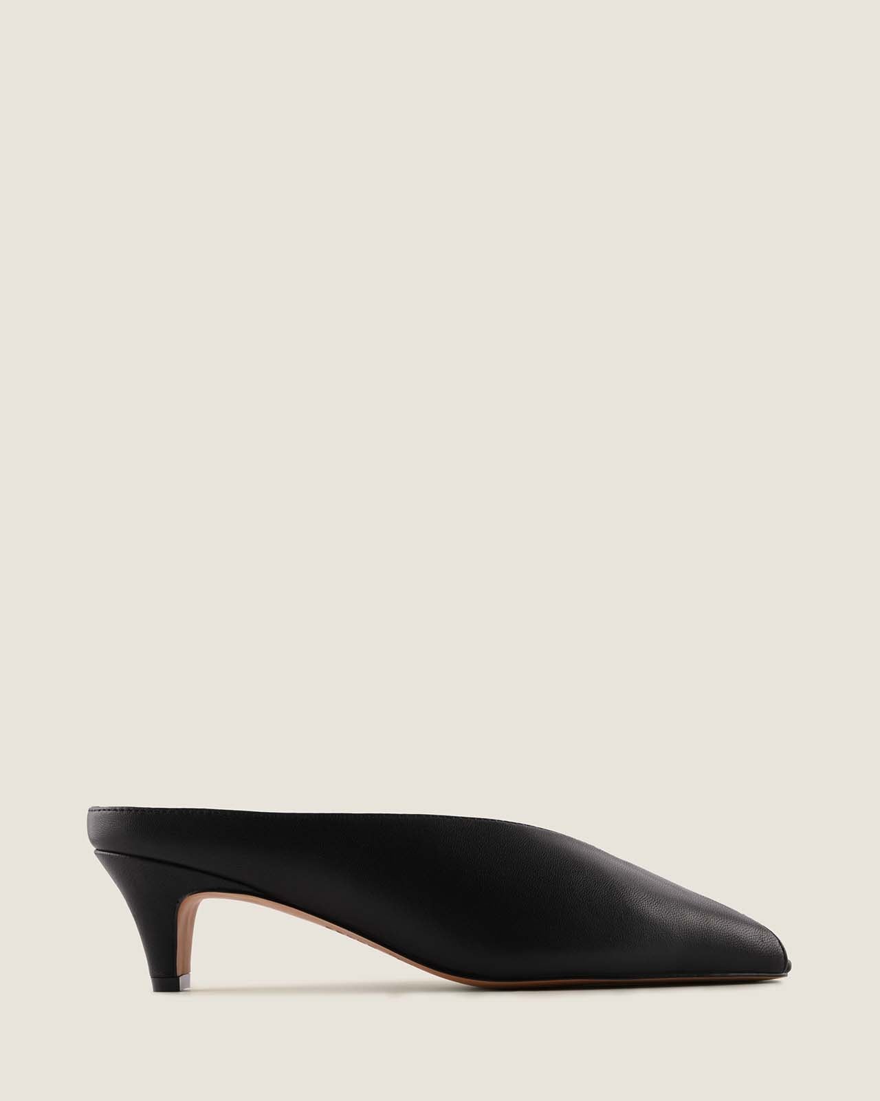 Black high-heeled shoe on a light beige background