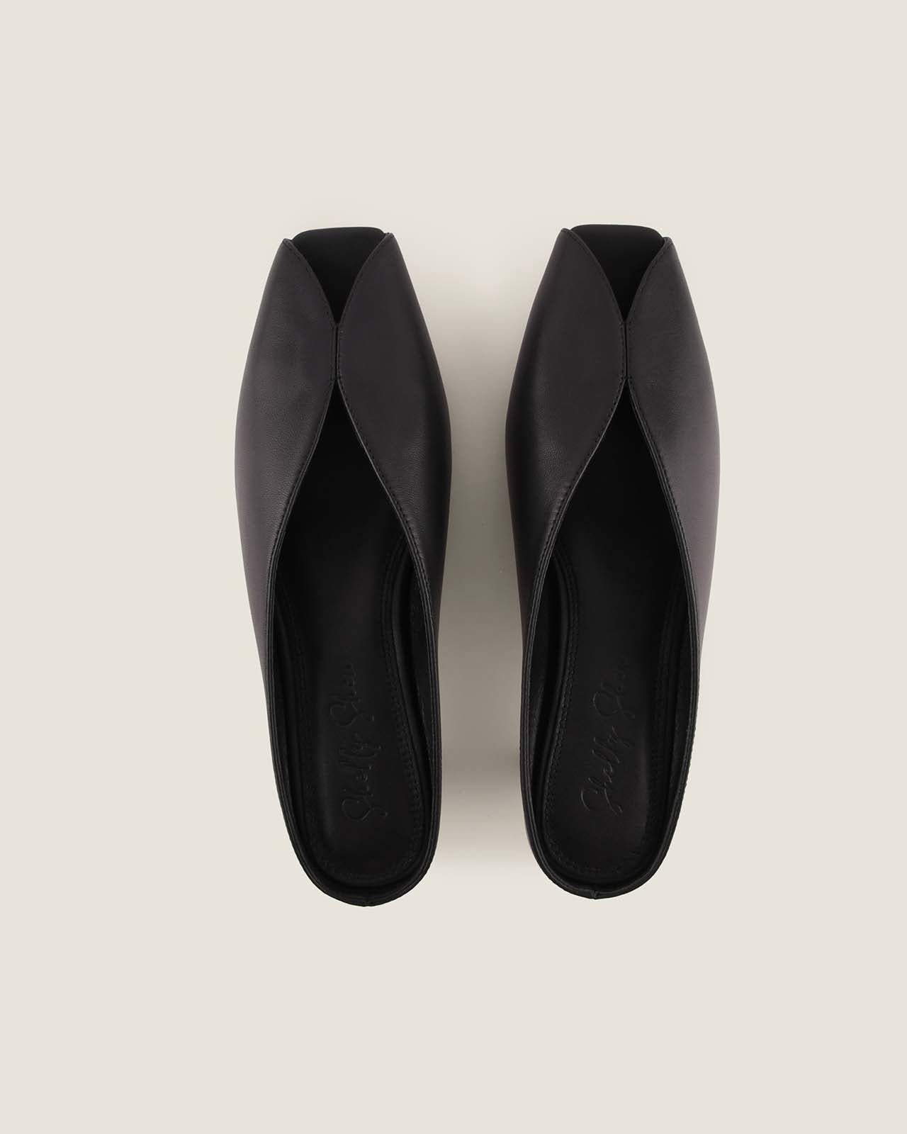 Pair of black high-heeled shoes on a light grey background