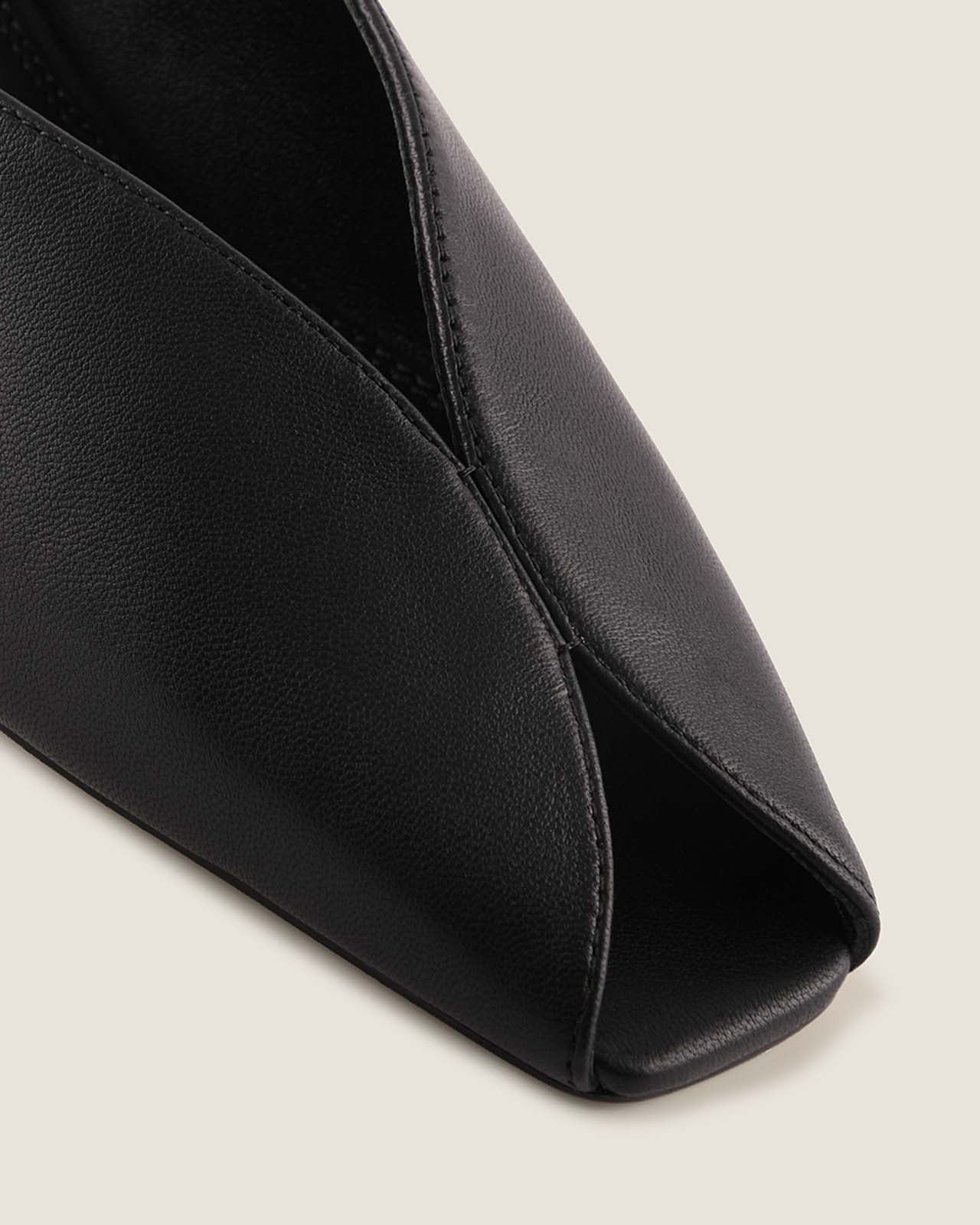 Black leather shoe on a light grey background