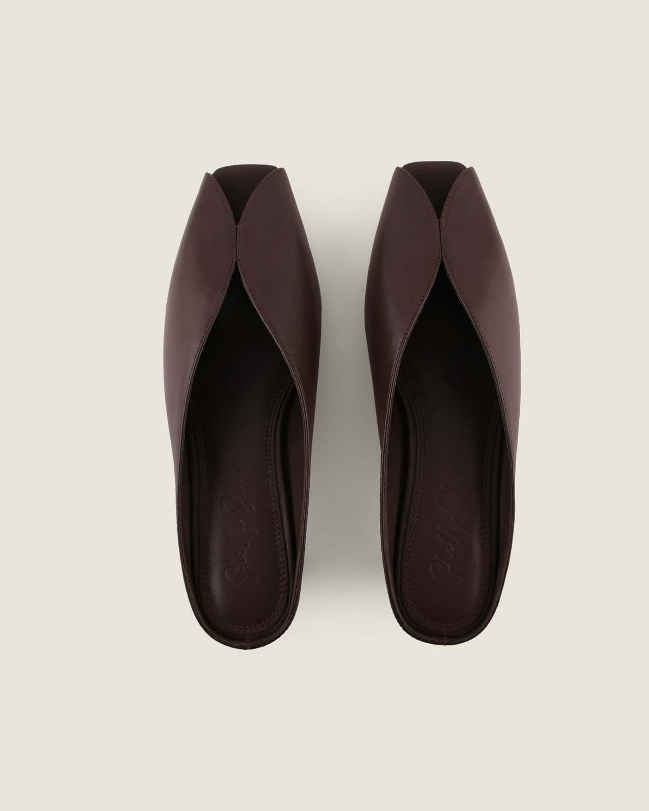 Pair of brown open-toe shoes on a light grey background