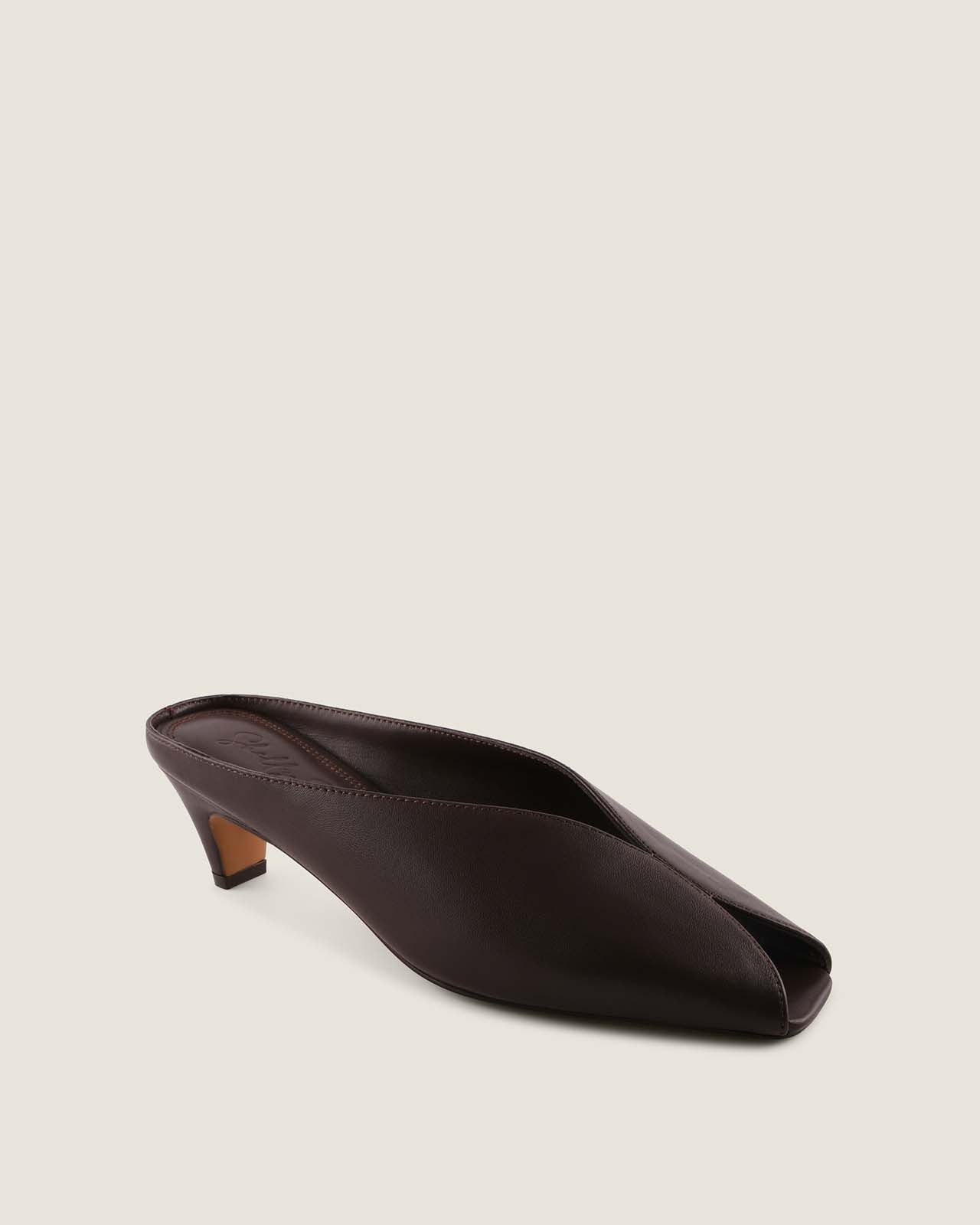 Brown leather shoe on a beige background
