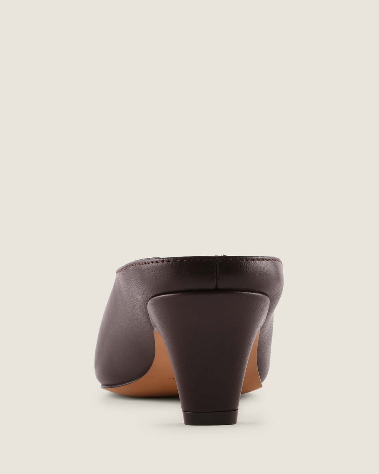 Brown high-heeled shoe on a light beige background
