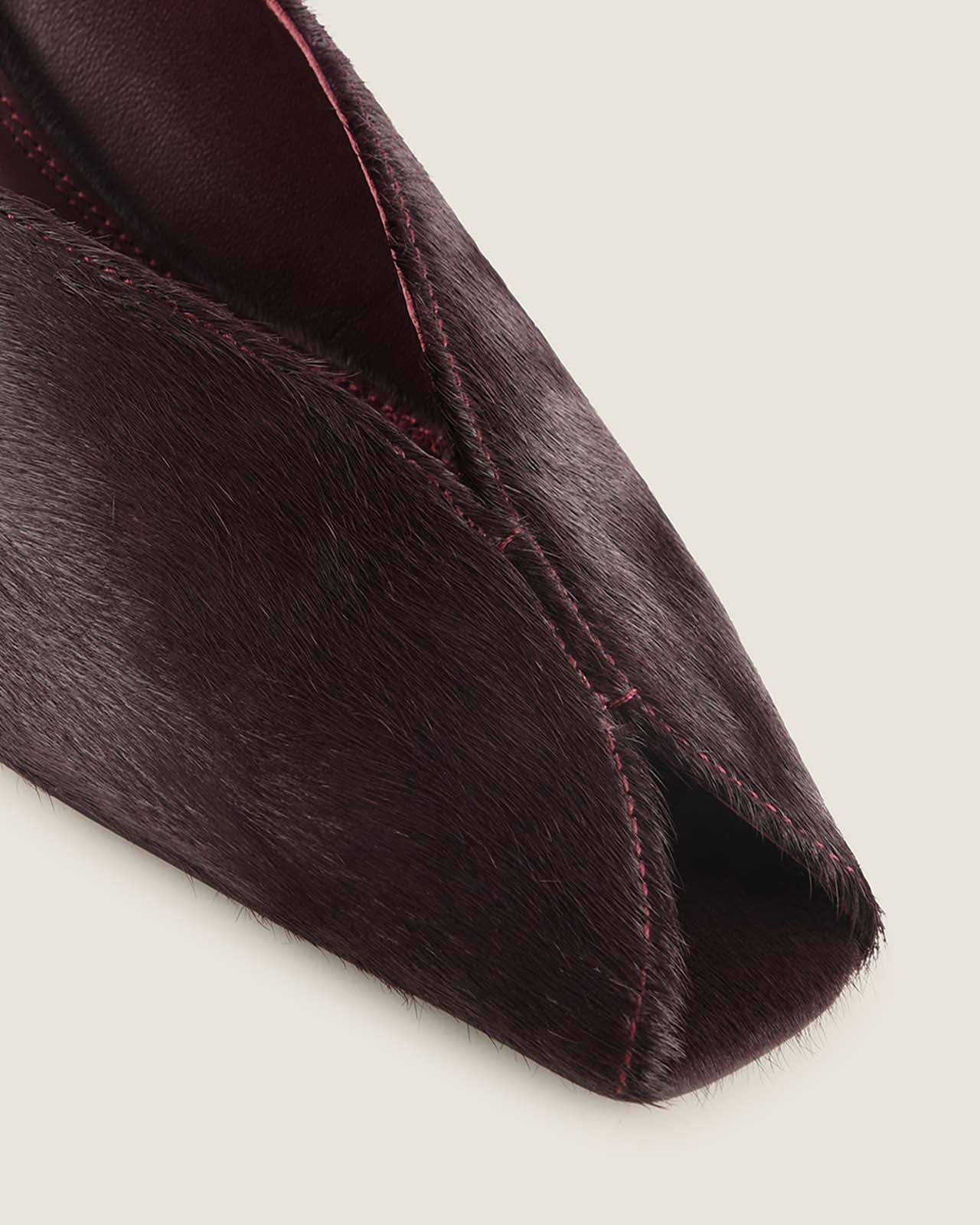 Burgundy open-toe shoe on a light grey background