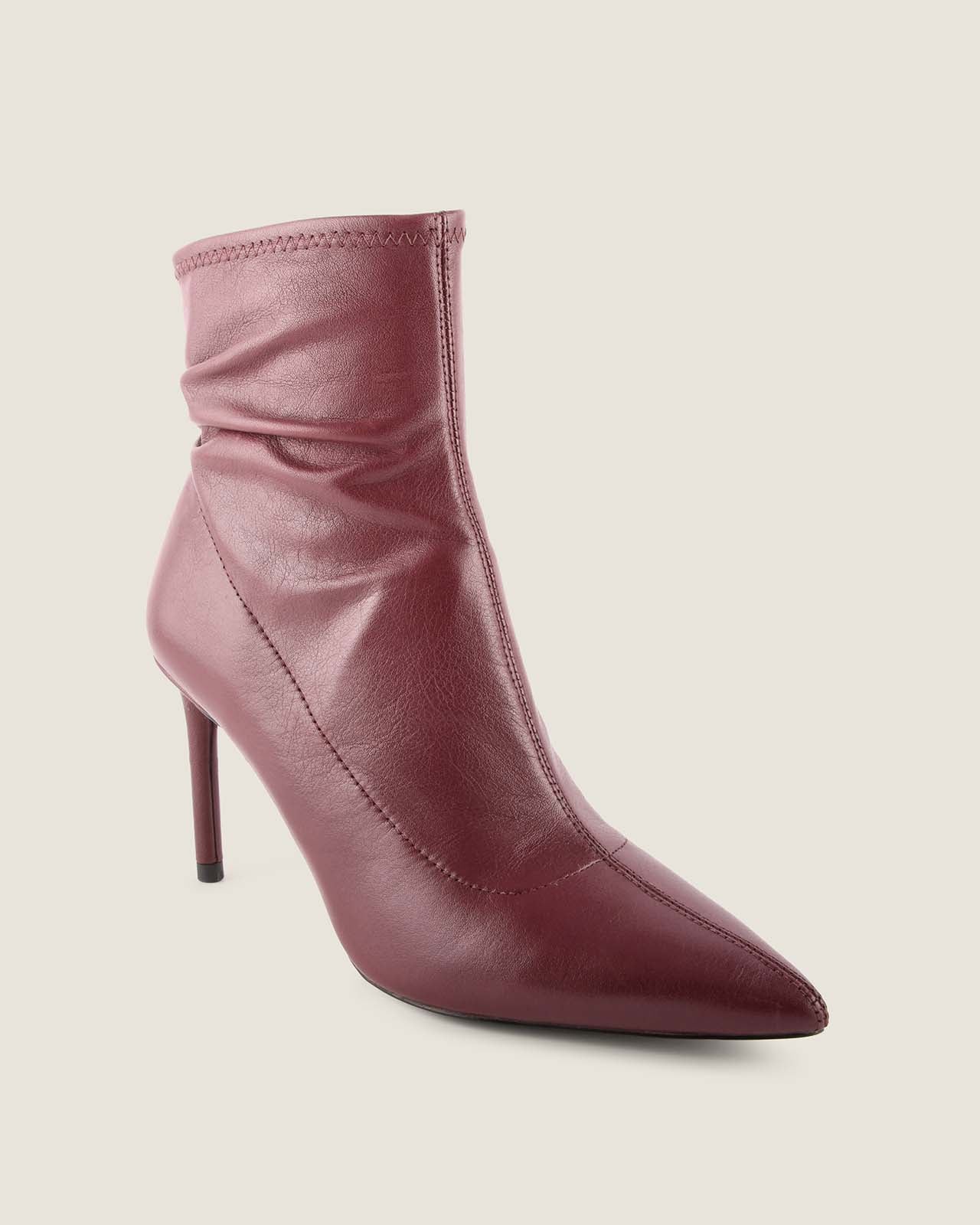 Burgundy high-heeled ankle boot on a light beige background