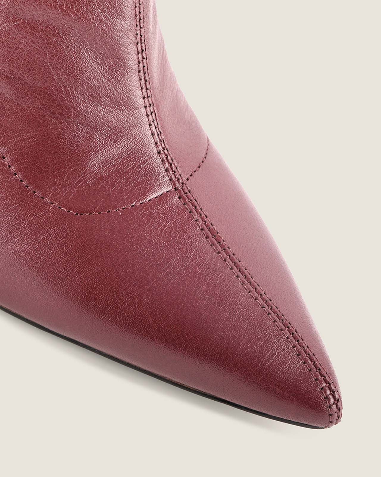 Close-up of a burgundy leather boot on a light background