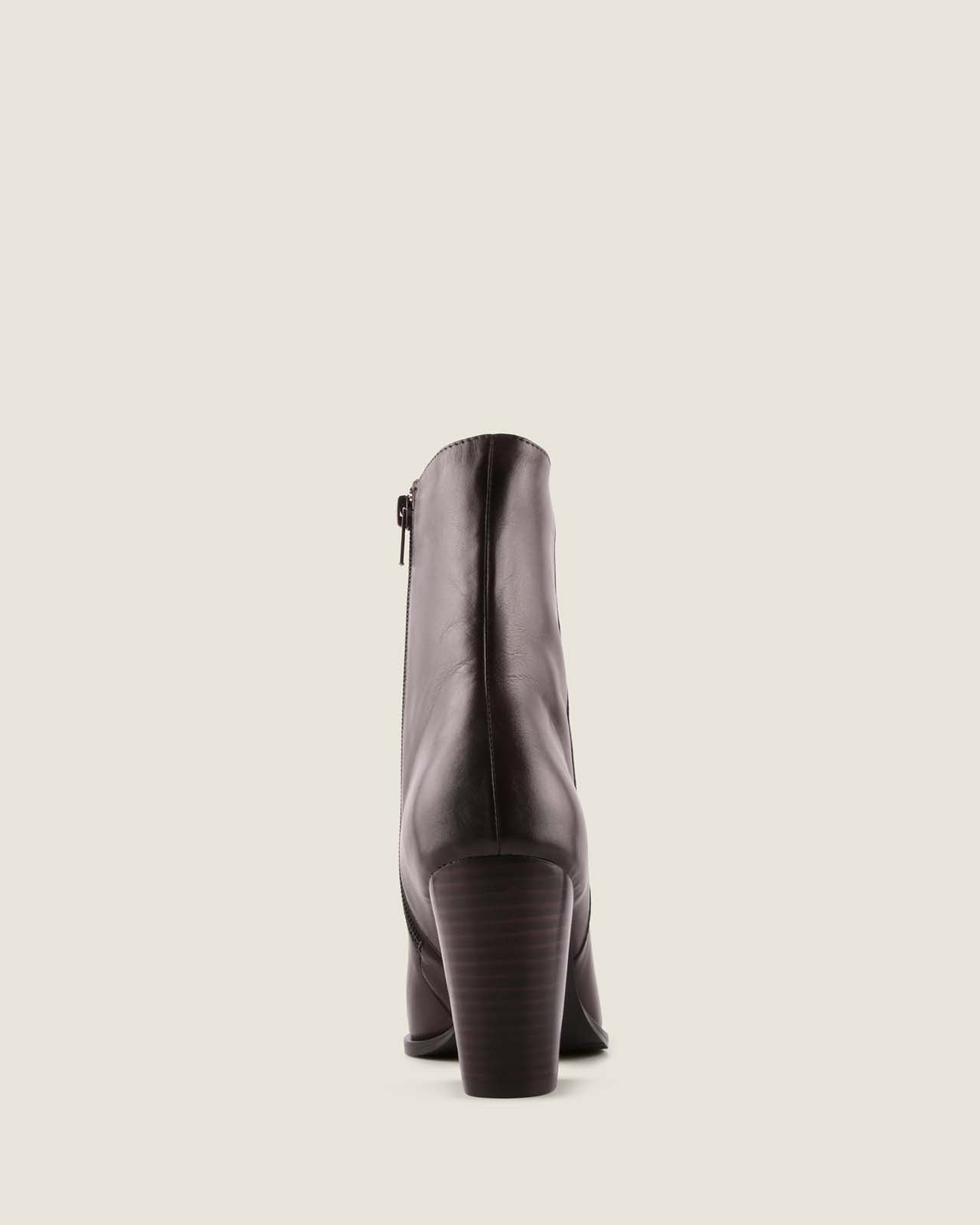 Dark brown leather ankle boot on a light beige background