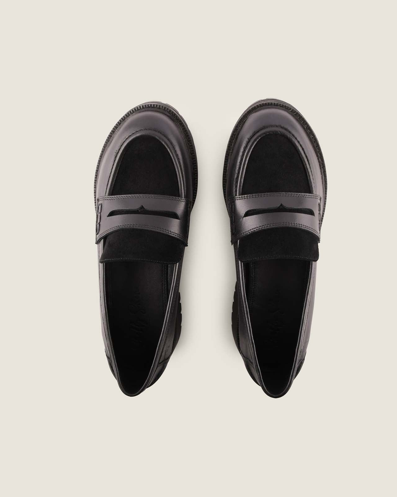 Pair of black loafers on a light background