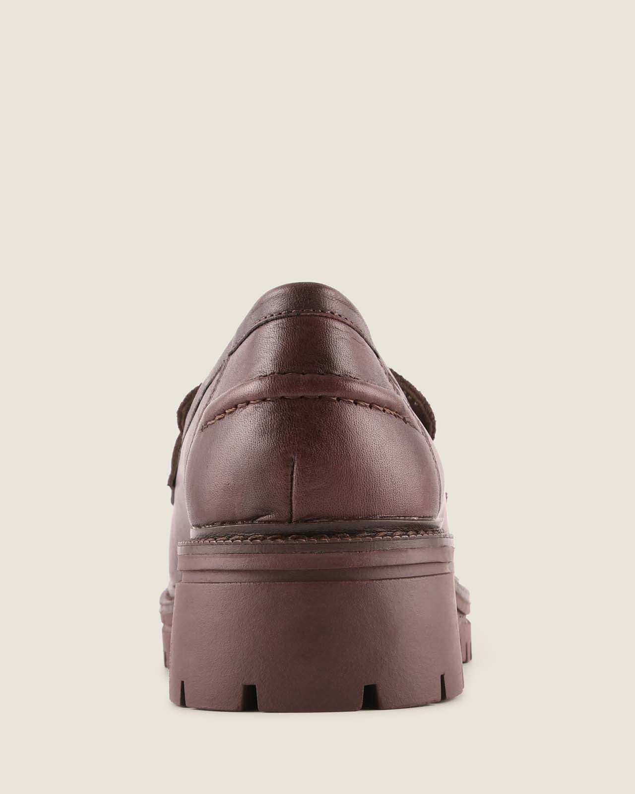 Brown leather shoe on a beige background