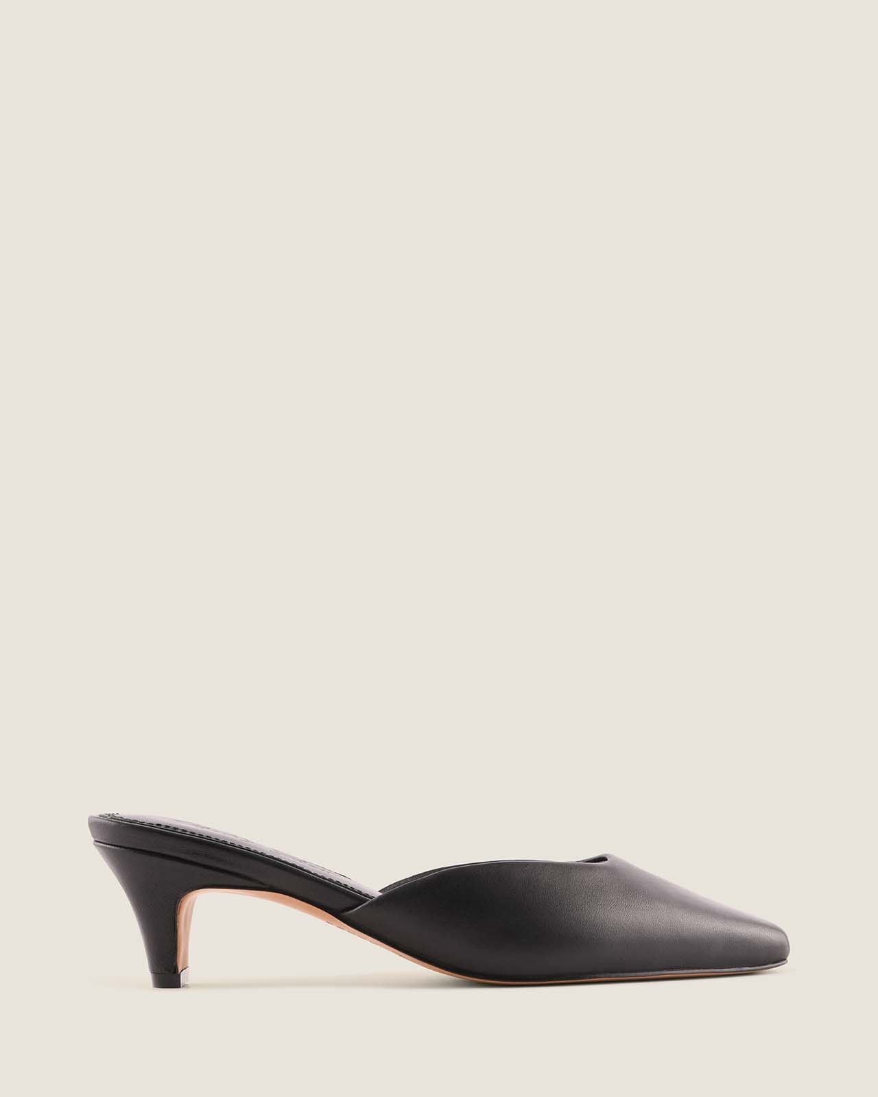 Black leather heel on a light beige background