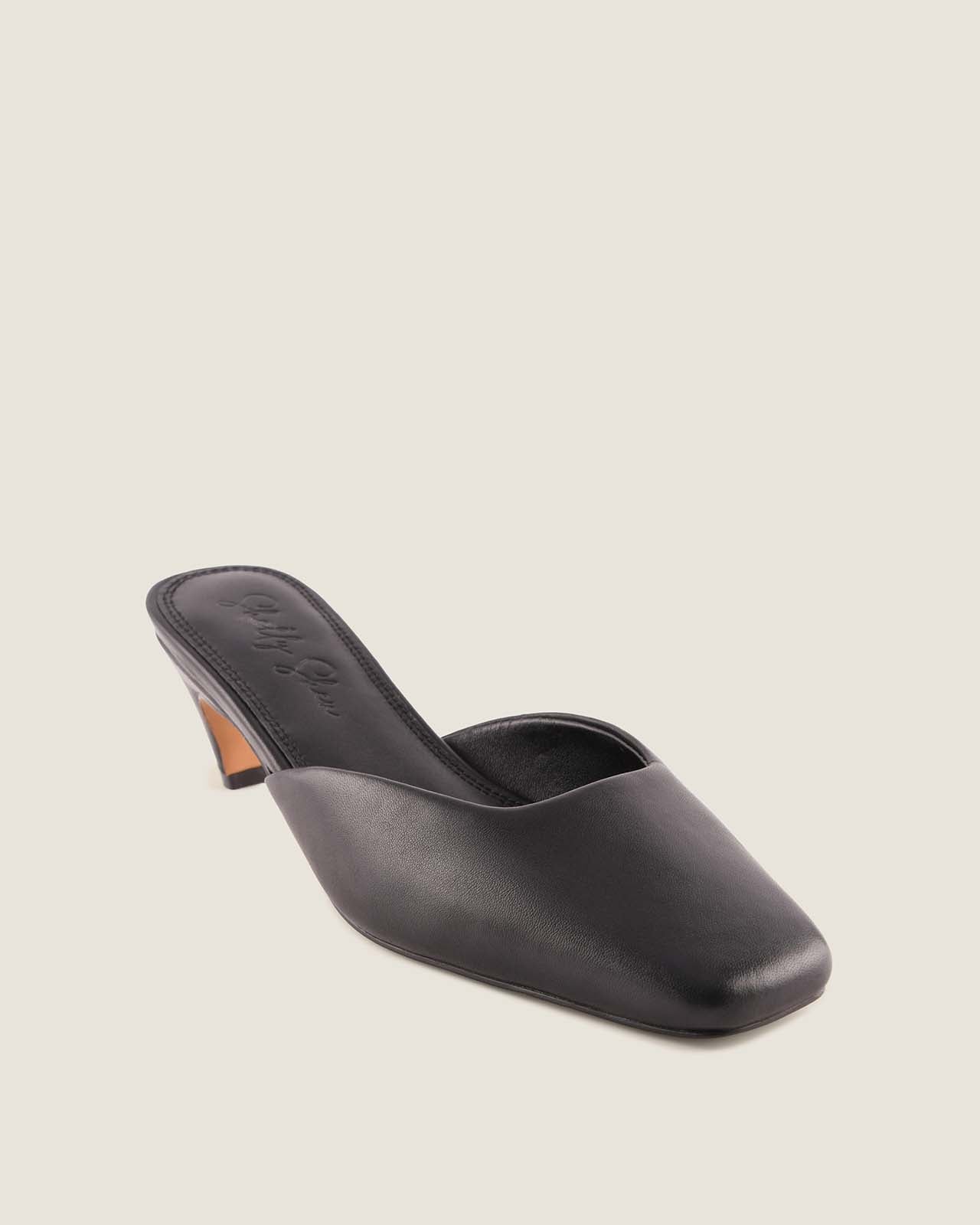 Black high-heeled shoe on a light grey background