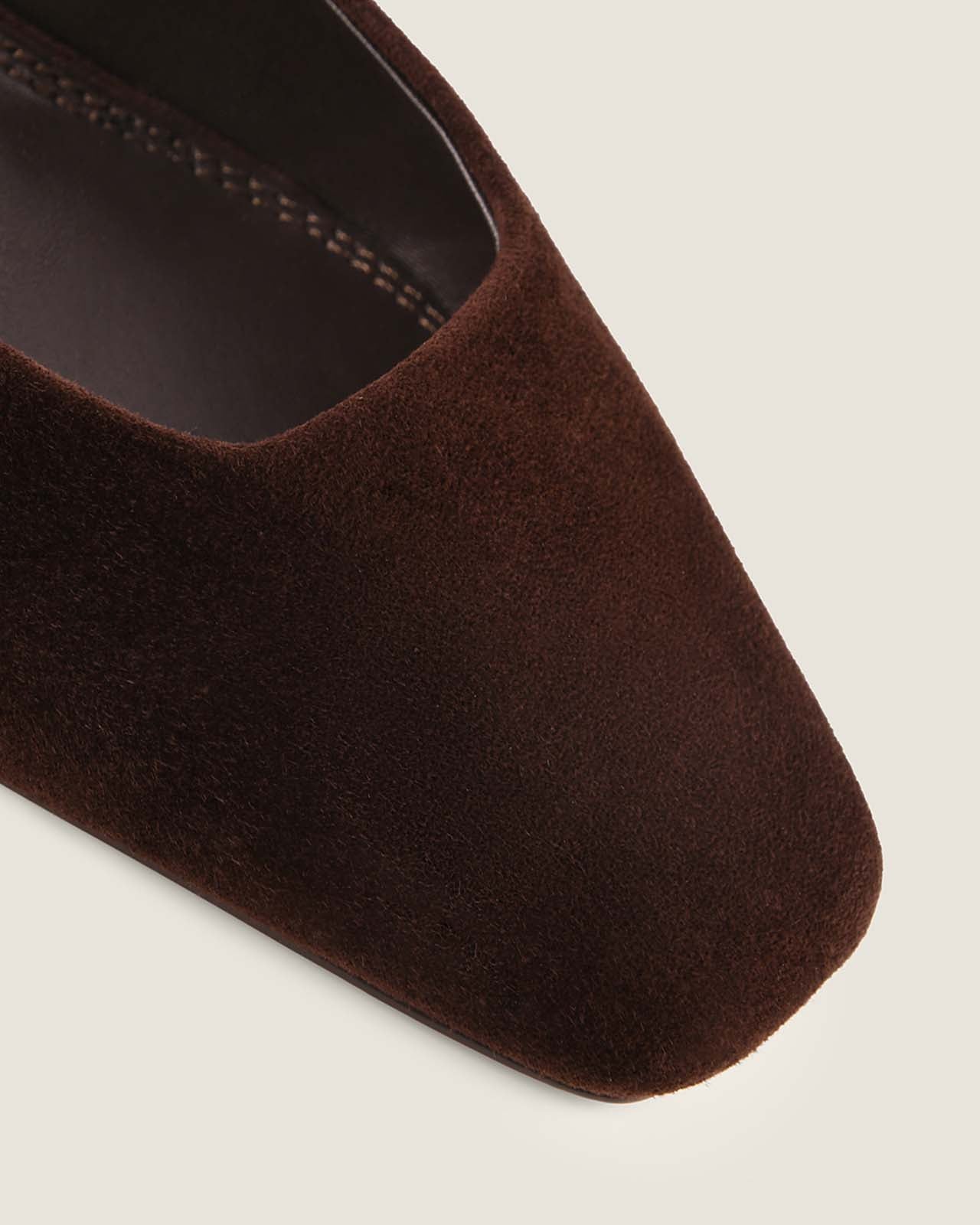 Brown suede shoe on a light grey background