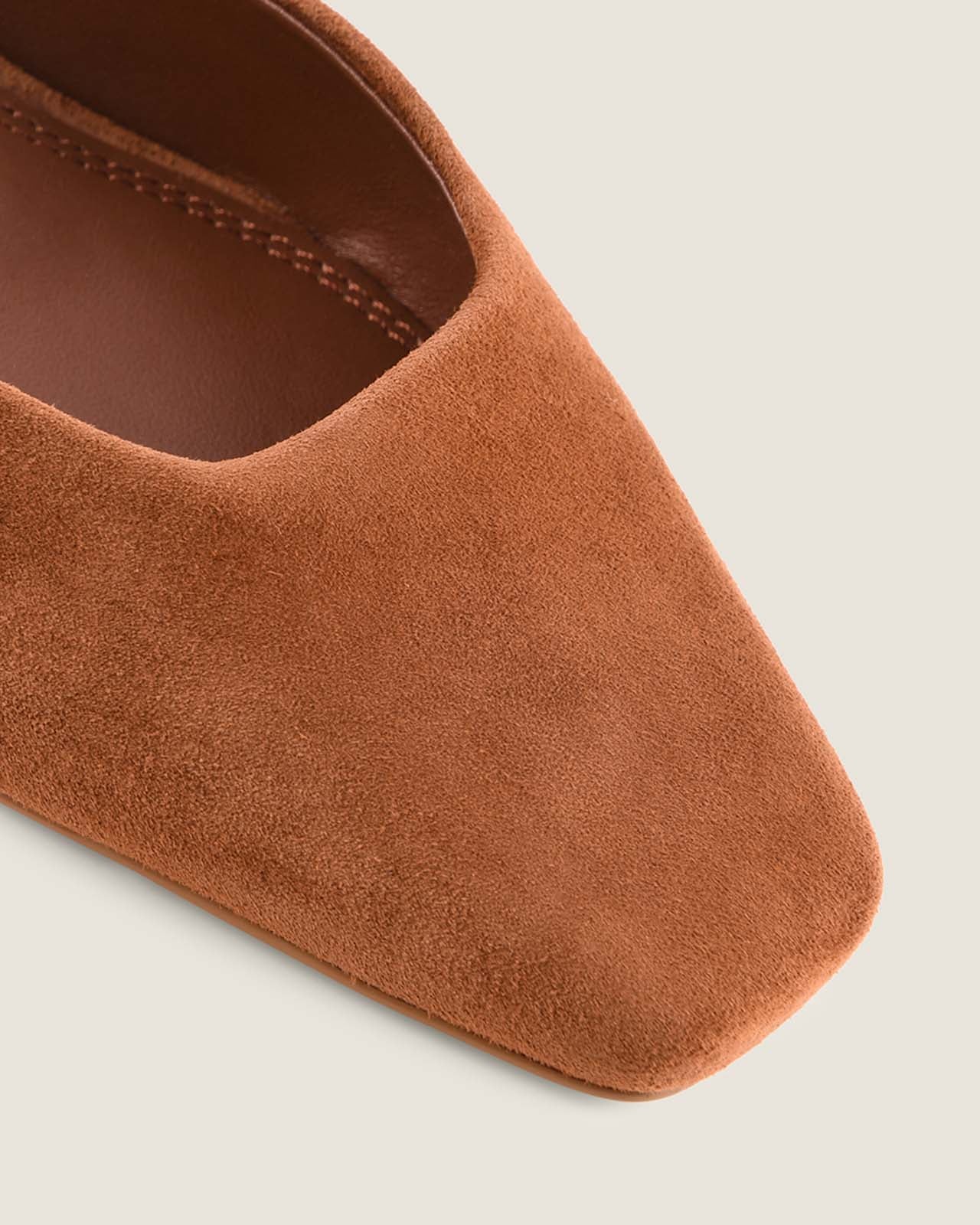 Tan suede shoe with a square-toe on a light grey background