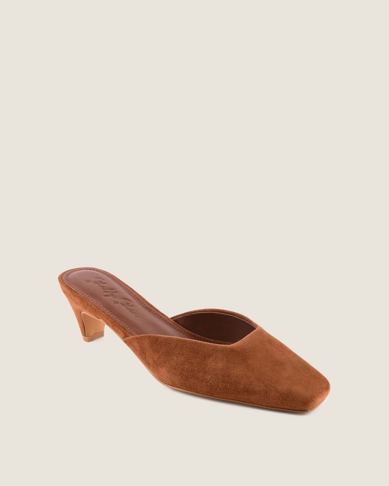Tan suede shoe with a square-toe on a light grey background