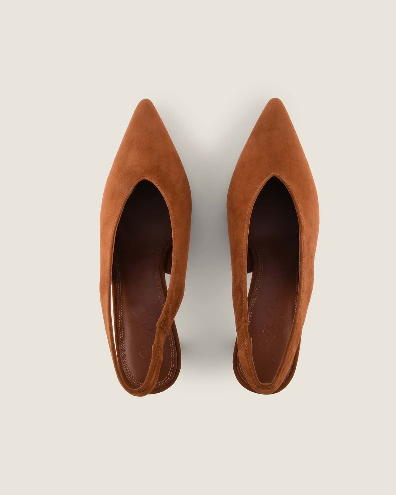 Pair of tan pointed-toe shoes on a light grey background
