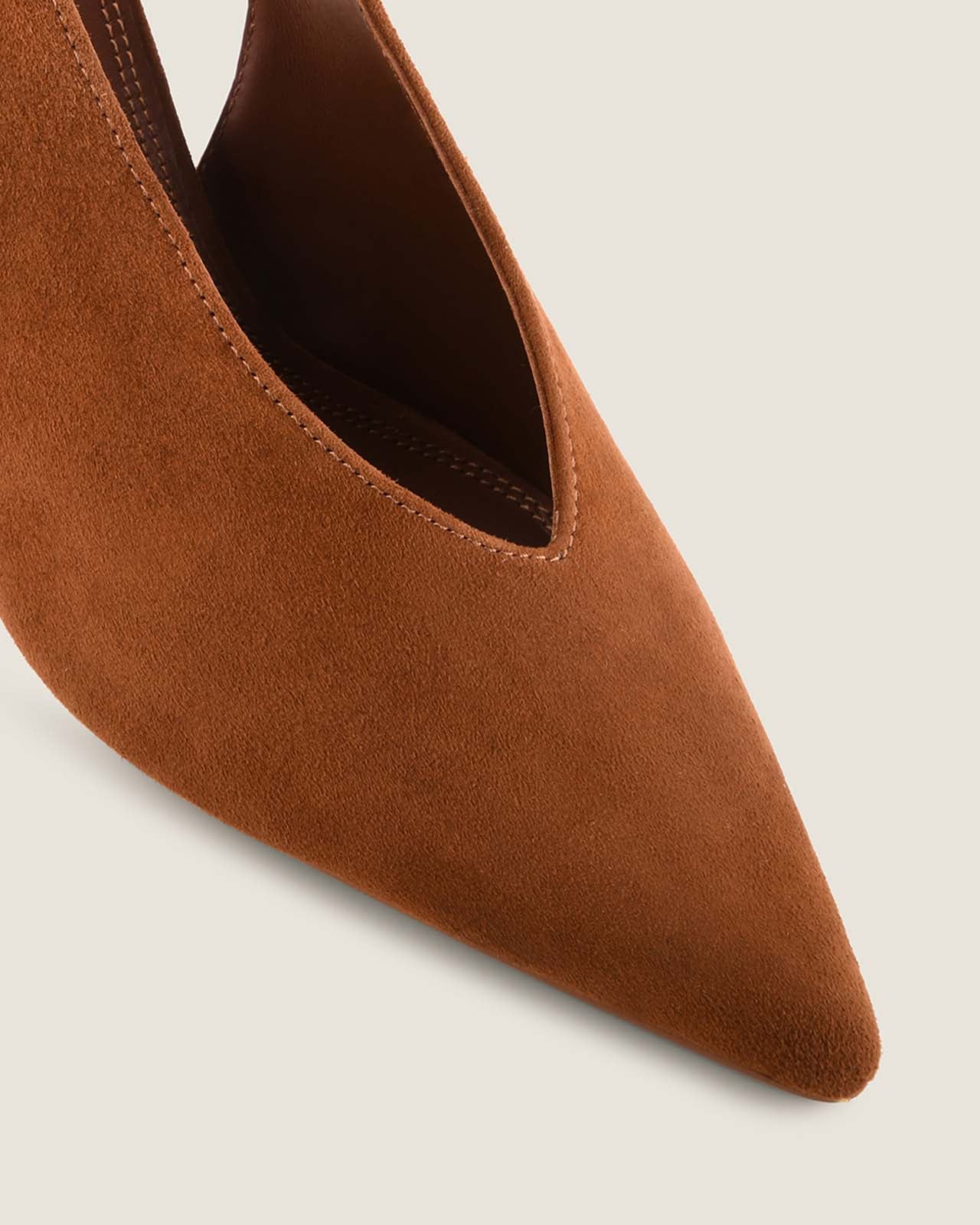 Tan pointed-toe shoe on a light grey background