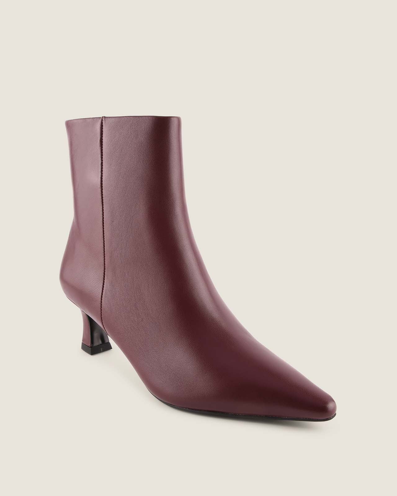 Burgundy ankle boot on a light beige background