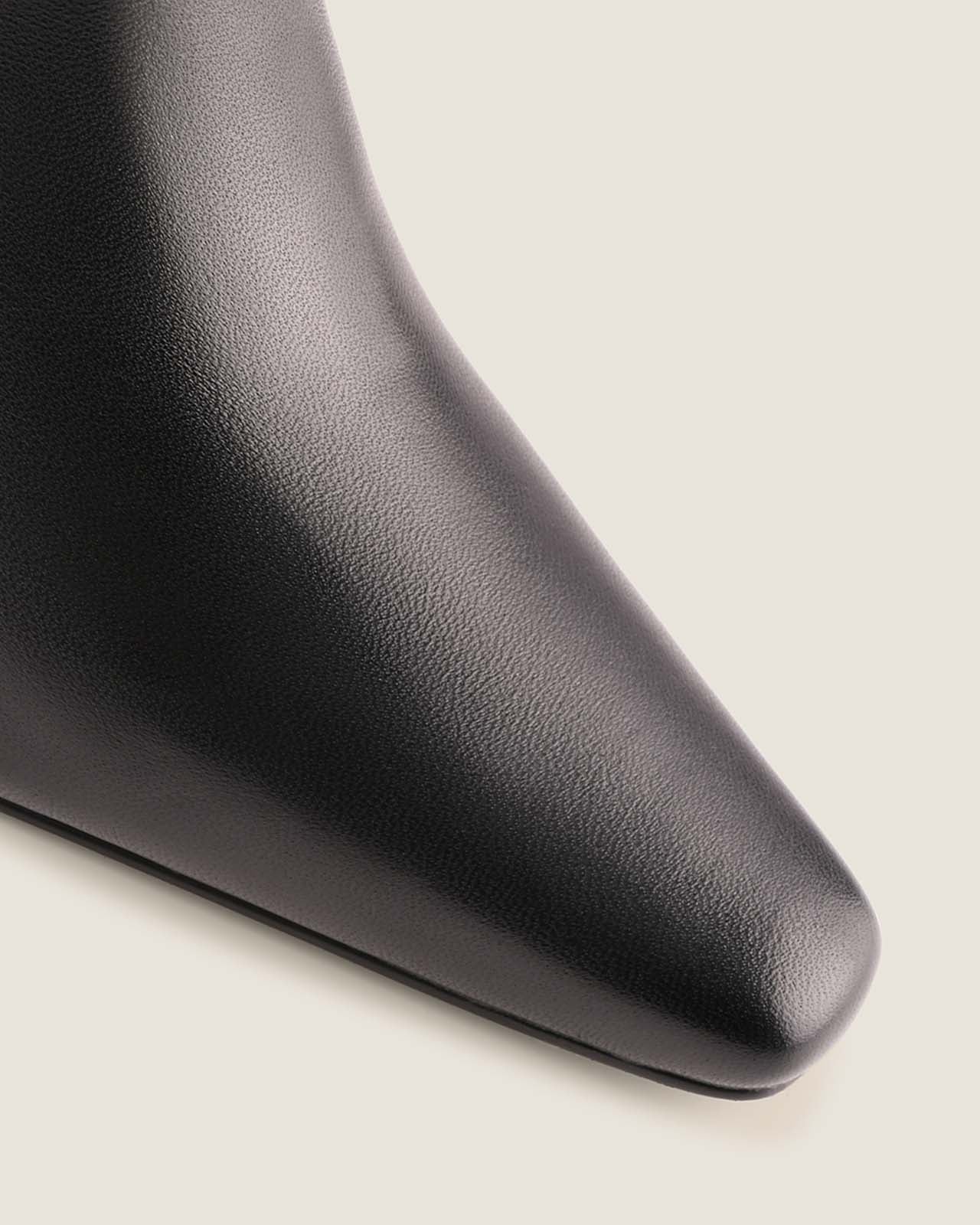 Close-up of a black leather shoe on a light background